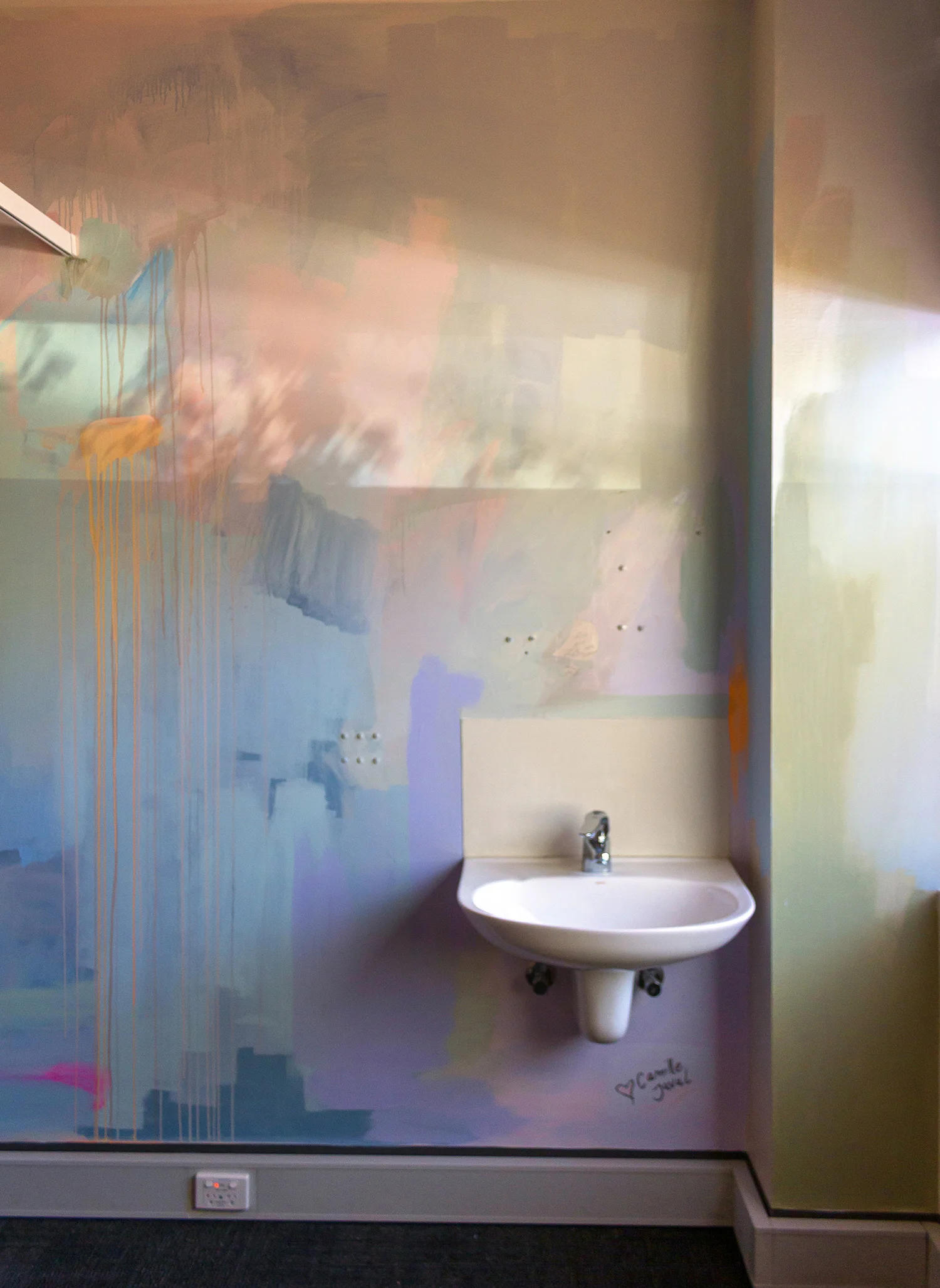 Pastel abstract mural painted in an OB/GYN office, shadows from the nearby window project tree leaves onto the wall.