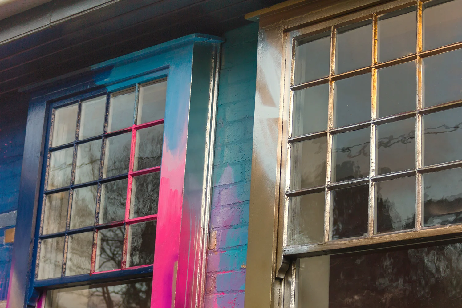 Close up of two windows that have been painted as part of a giant abstract installation on the outside of a residential property.
