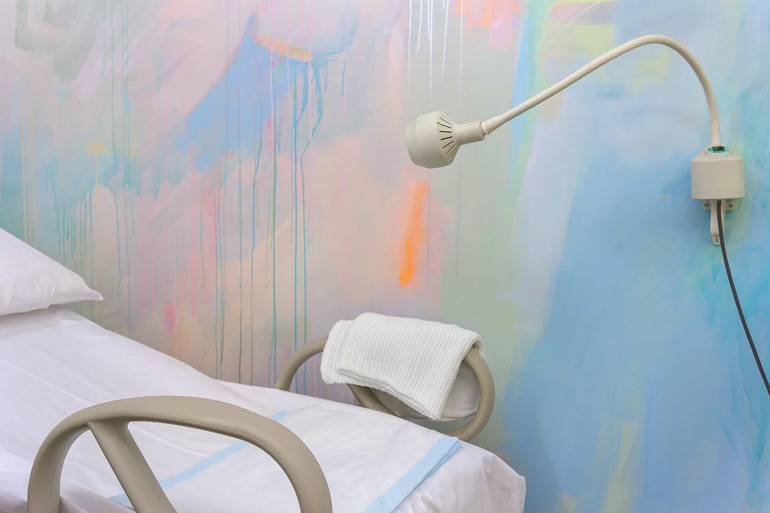 Close up of pastel abstract mural painted in an OB/GYN office, featuring medical equipment and paint details.