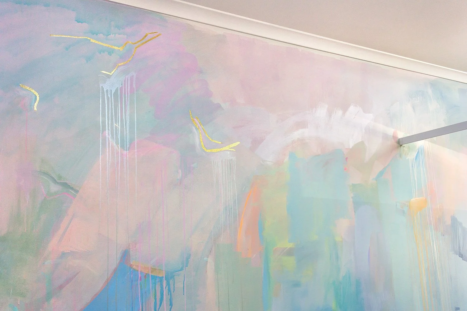Pastel abstract mural painted in an OB/GYN office, featuring gold gilded birds flying across the wall and glowing metallic pink paint.