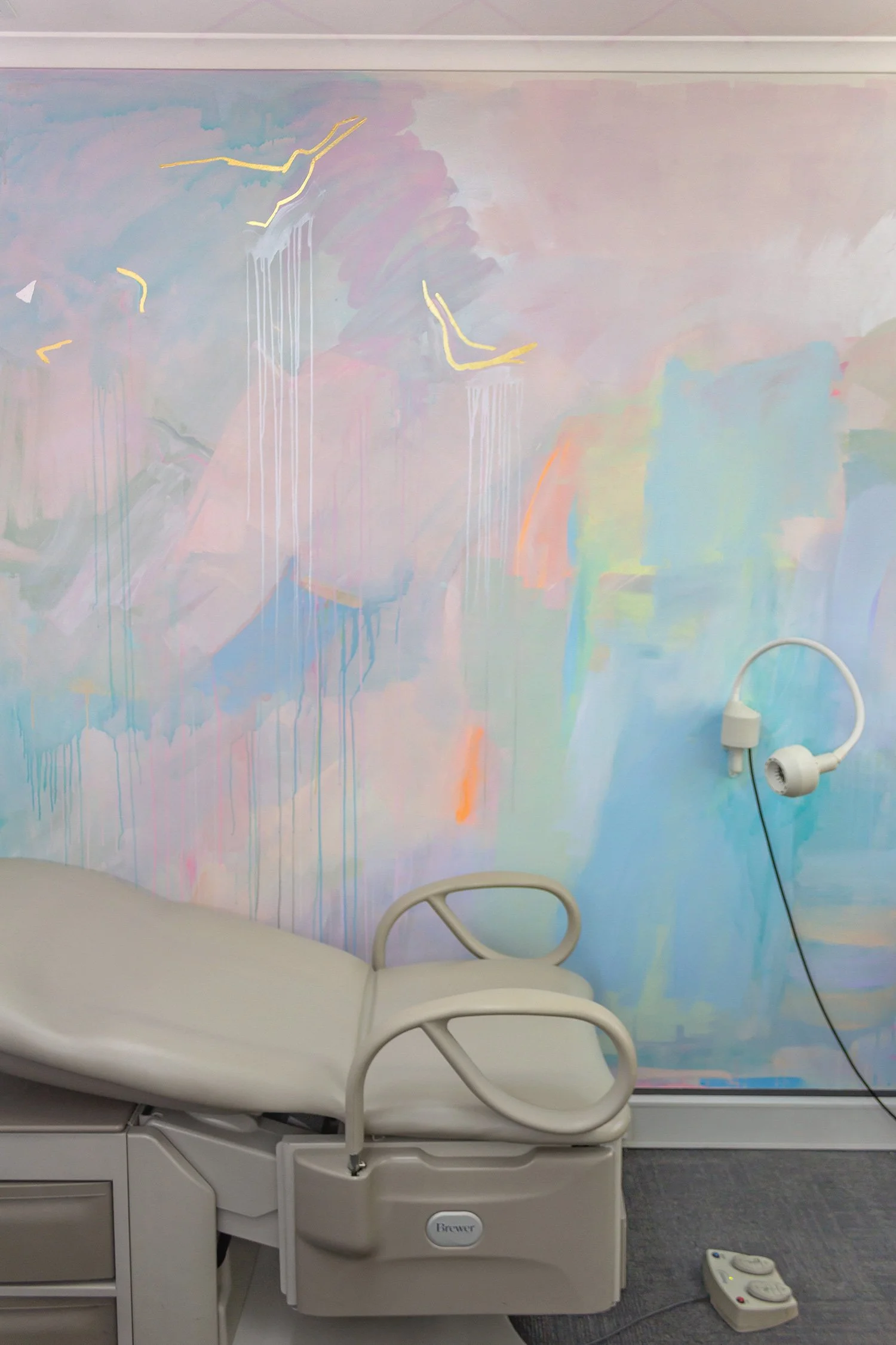 Pastel abstract mural painted in an OB/GYN office, featuring gold gilded birds flying across the wall and glowing metallic pink paint.