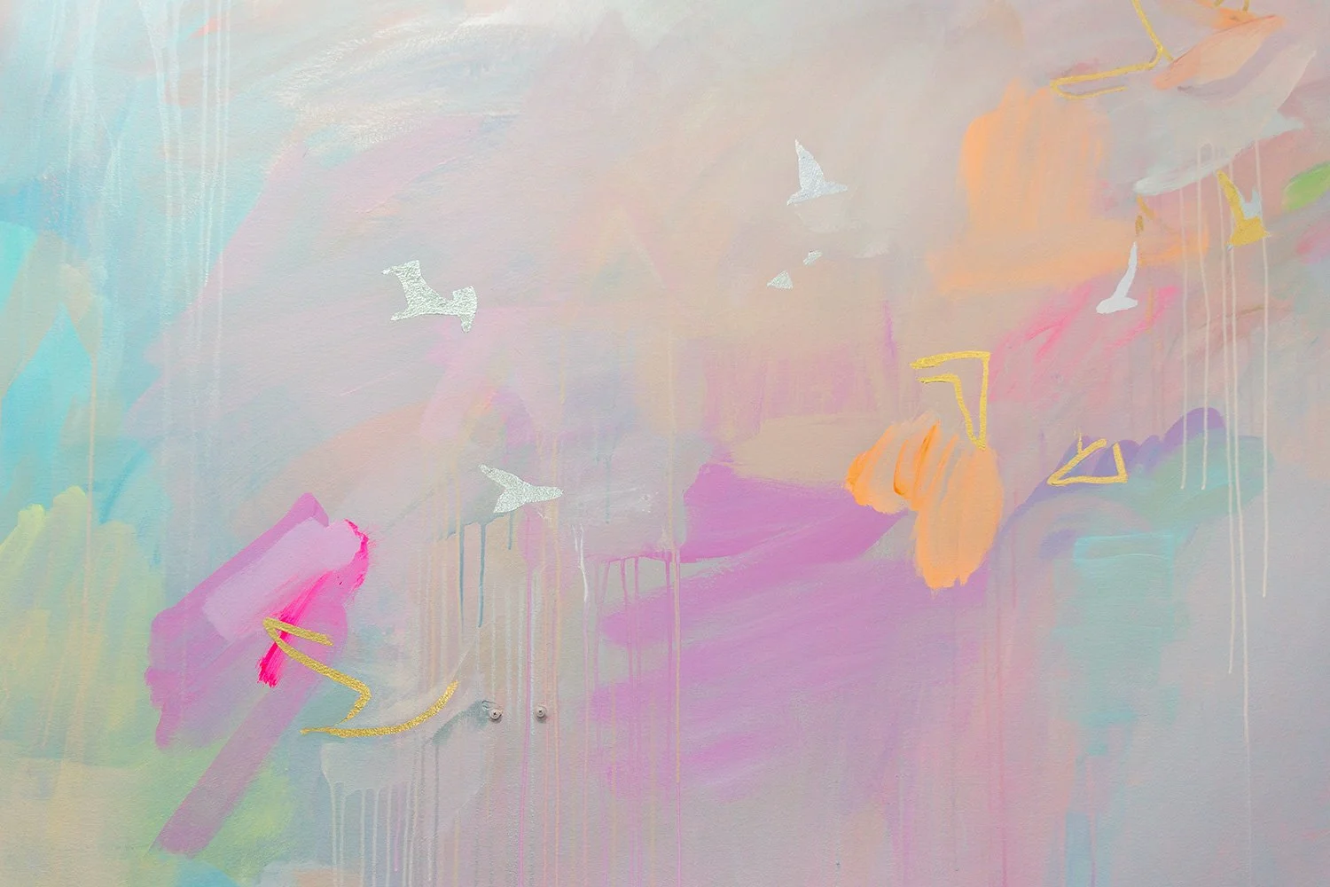 Close up of pastel abstract mural, featuring gold and silver gilded birds flying across the wall.