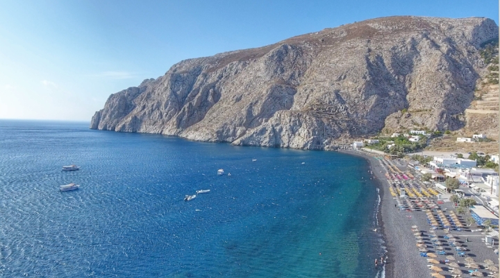Kamari is 40min driving from Oia. This place is unique for its black & rocky sand. There is this seaside main street full of restaurants and shops. If you consume in one of the restaurants, they will give you for free a sun-bed and umbrella. This one is quiet and peaceful.
