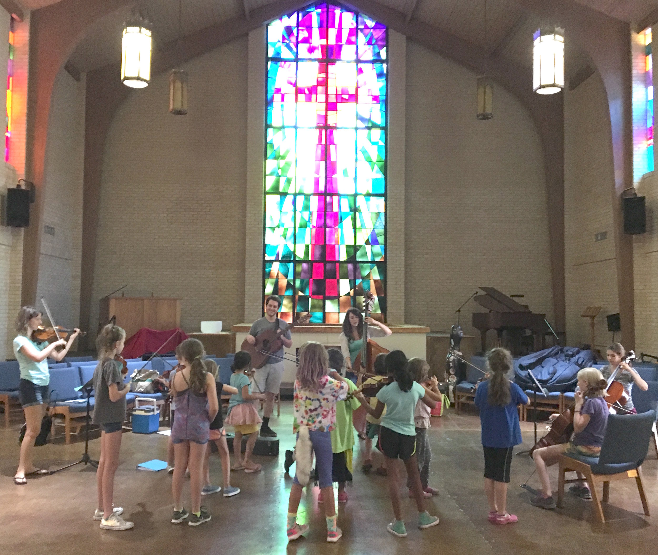 Sasha and Dana teach an original song to students at the Songbird Rising Summer String Camp.