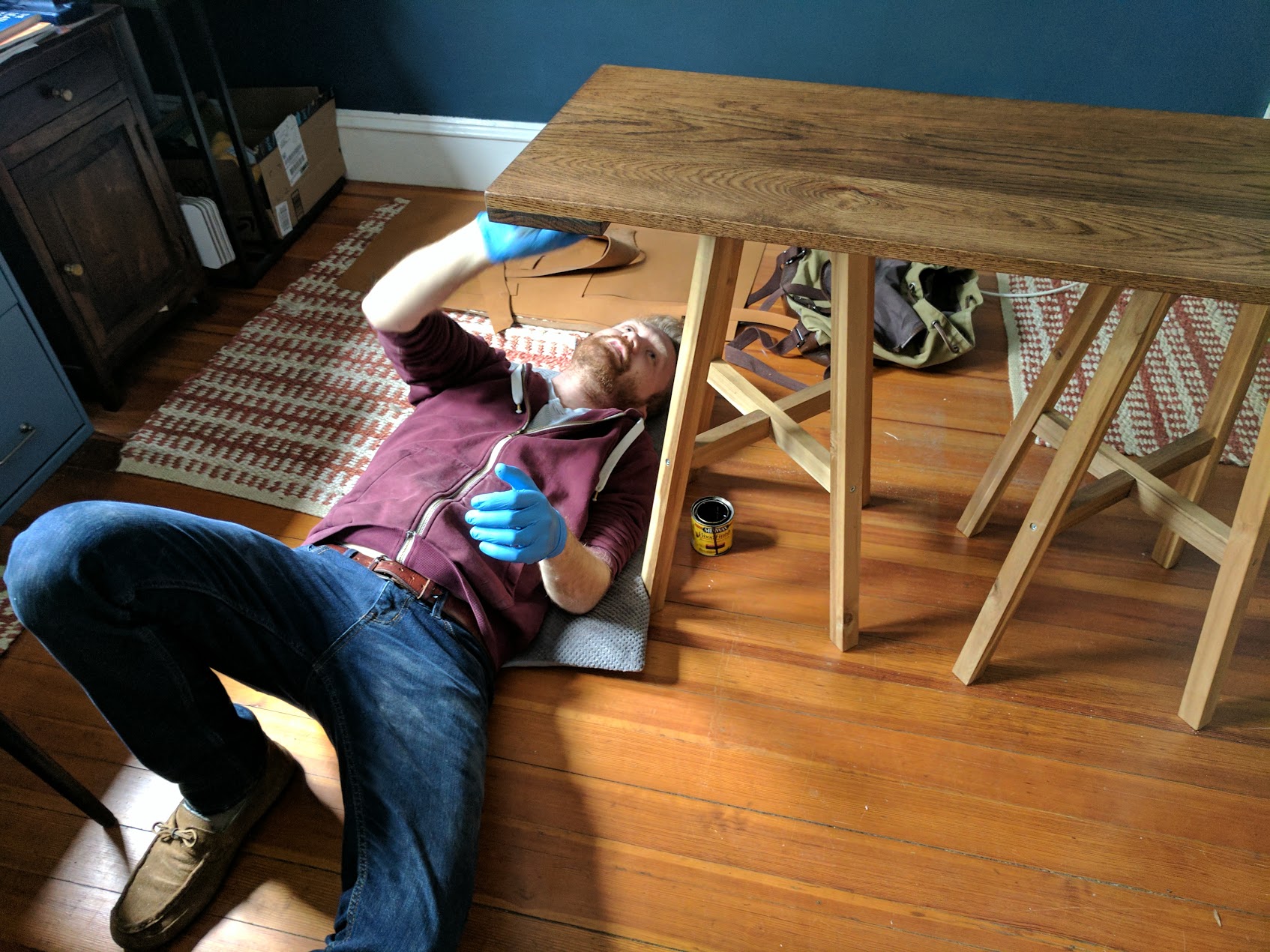 Laying on my dog's bed while I apply stain to the underside of the base.