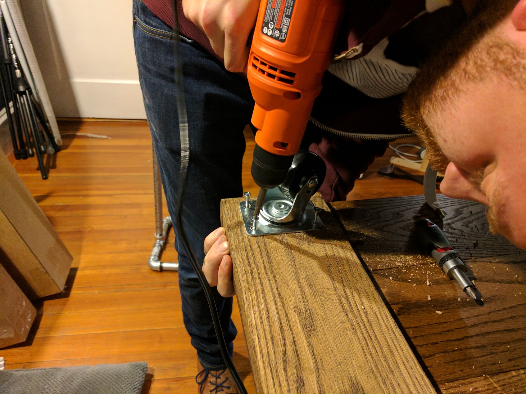 Screwing in the wheels on the bottom side of the base.