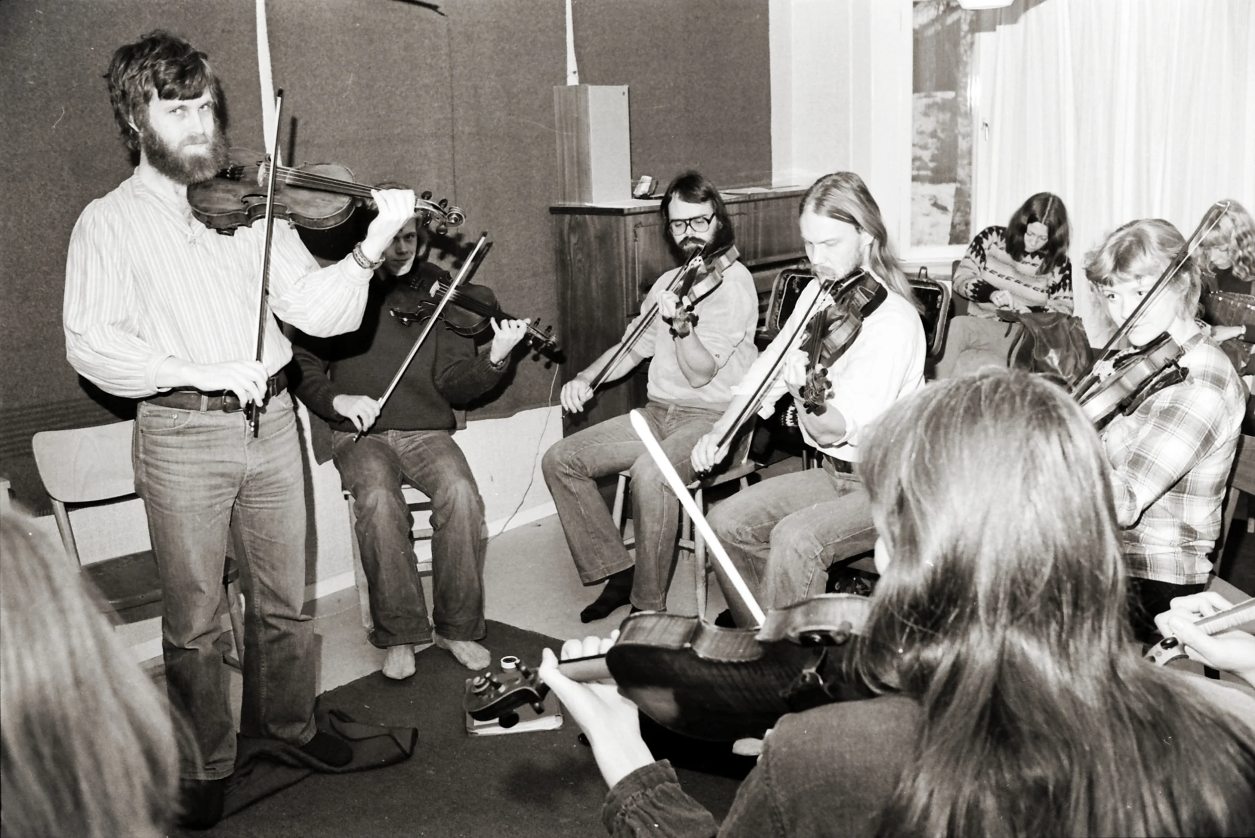 Jonny Soling, stående, och hans första elever på Malungs folkhögskola. Bilden är från december 1979. I motiveringen till Knis Karl-stipendiet 2017 står bland annat: ”Jonny är unik i sitt värv som pedagog (…) med otaliga spelmän från Sverige och världens alla hörn bland sina adepter.” Foto: Hans Bohm