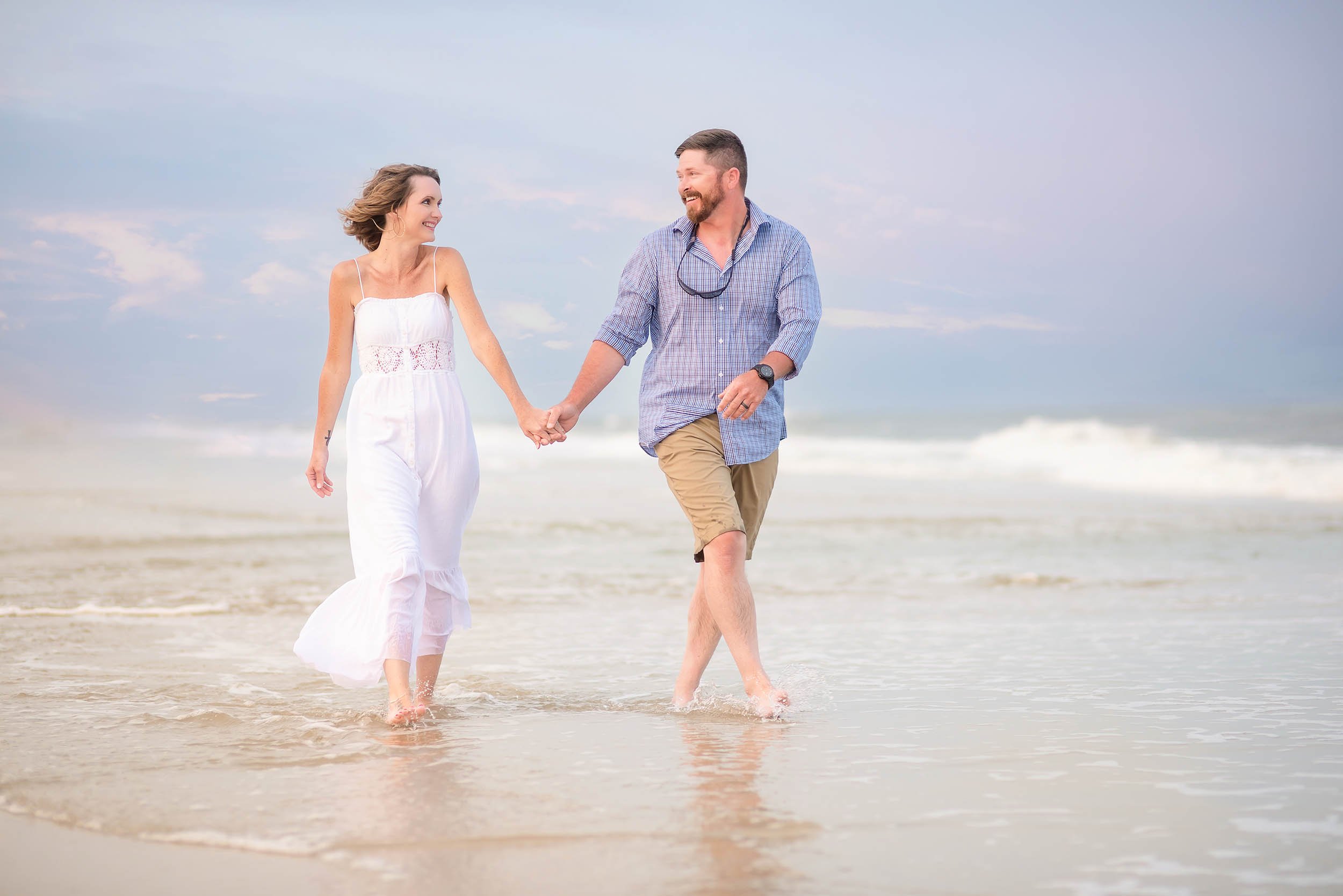 Photo of couple walking down the beach