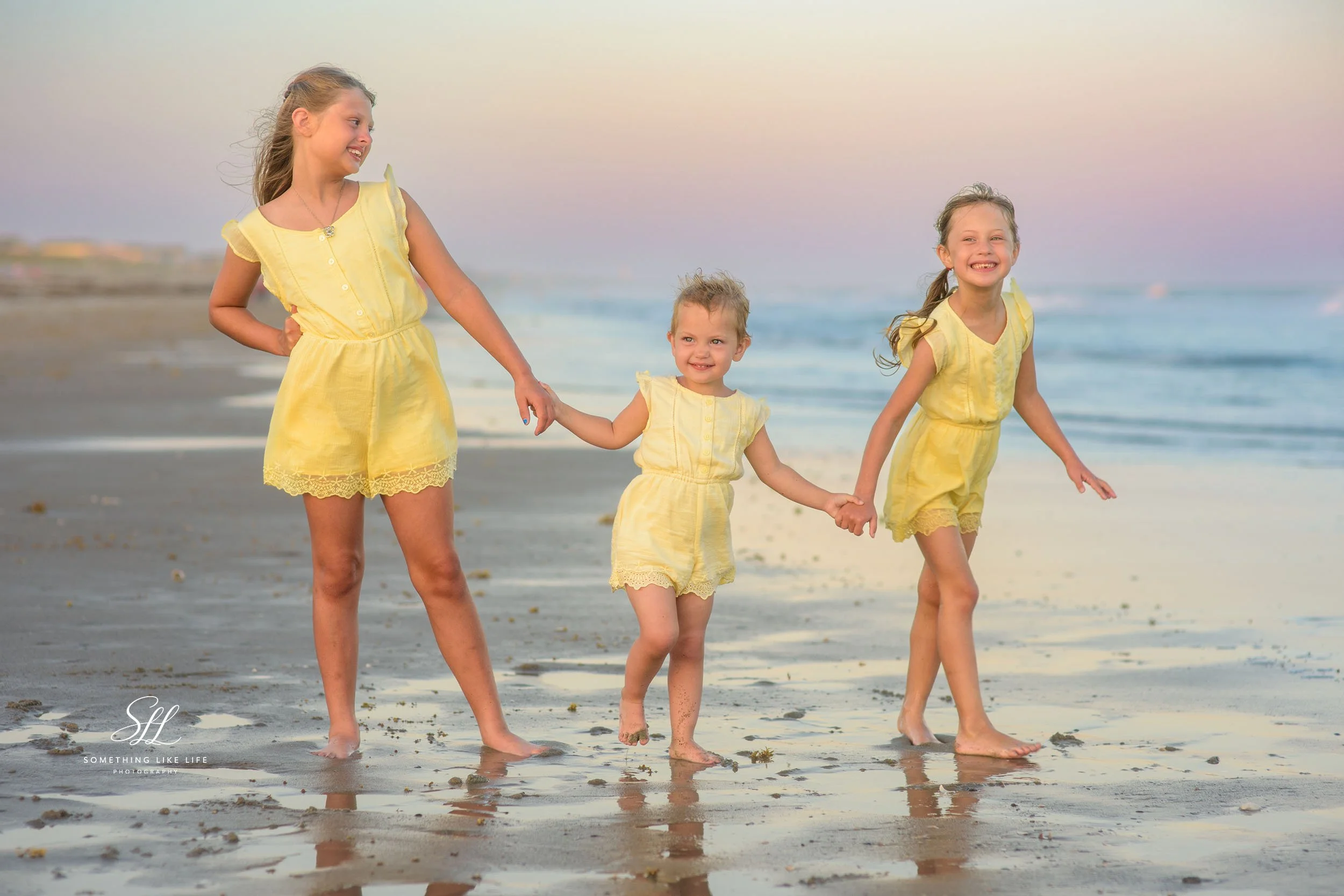 Three Sisters Holding Hands at Sunset | Holden Beach NC Family Photographer