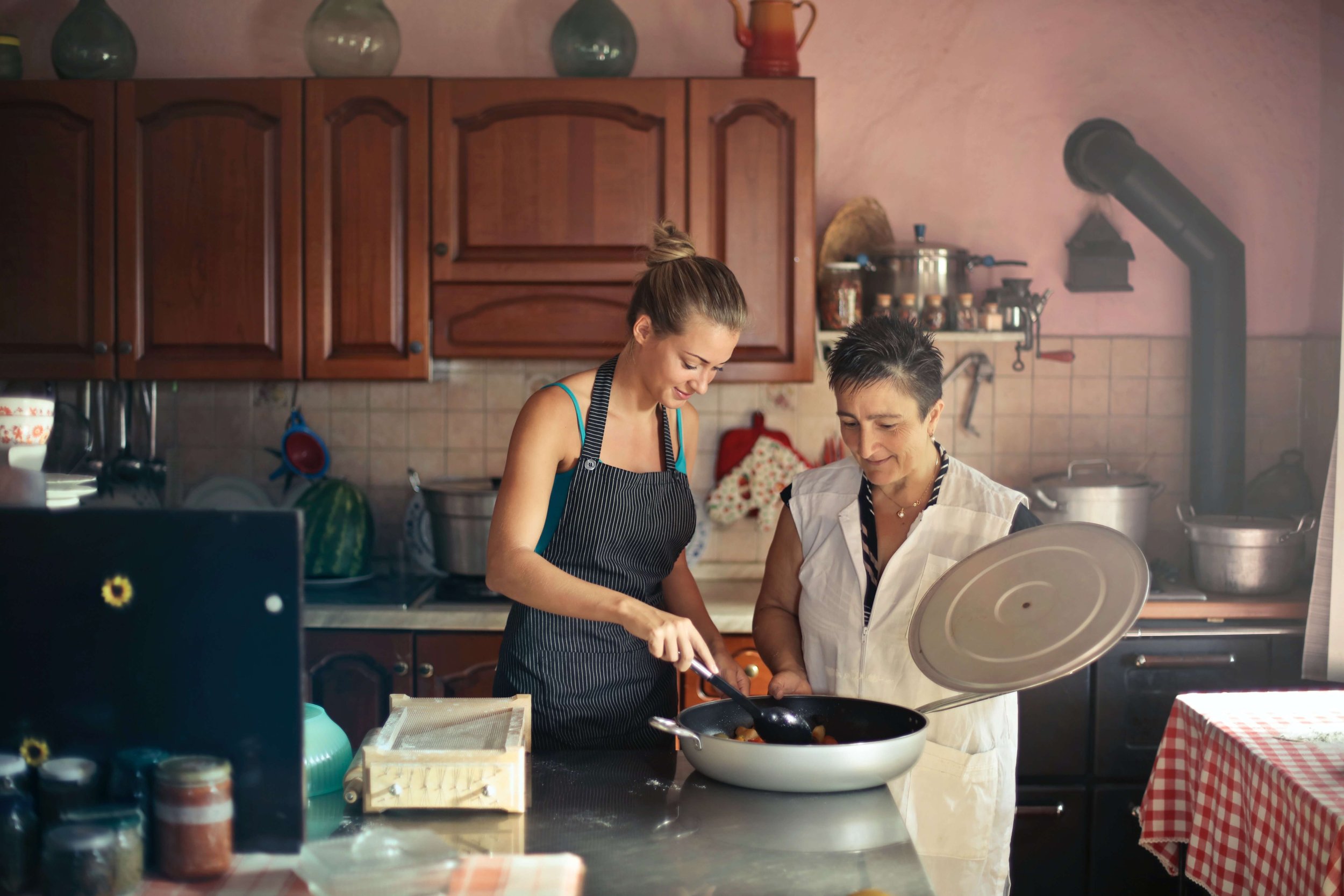 A young woman cooks with her mother as she navigates the transition to adulthood. Find your place with the help of Therapy for Young Adults in NYC.