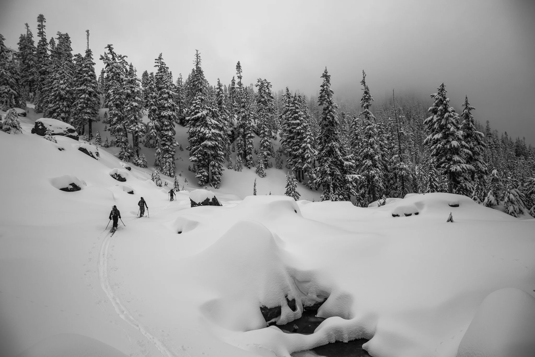 Making toward Avalanche Peak for deep tree skiing on the west faces above Snow Lake.