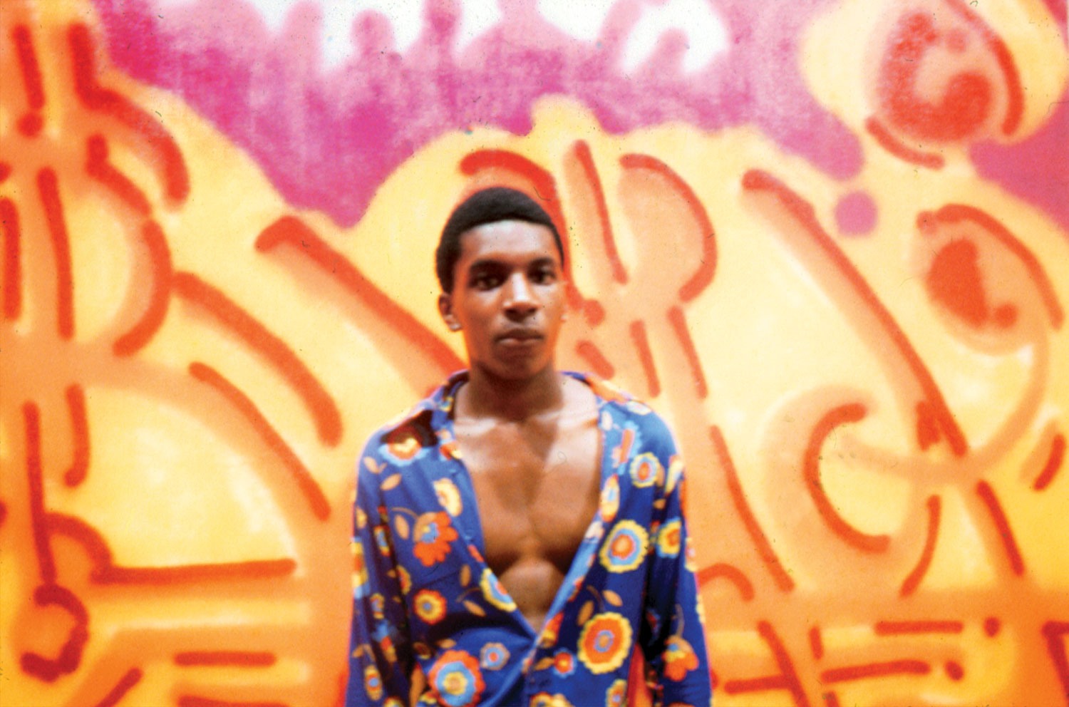 BAMA poses in front of his painting "Orange Juice" at the Razor Gallery. 1973.