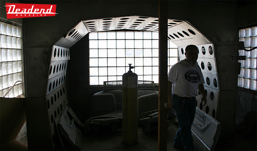 Here Flat Top Bob stands in an old paint booth at his buddy's shop