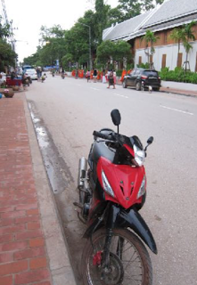 Scooter and monks collecting alms