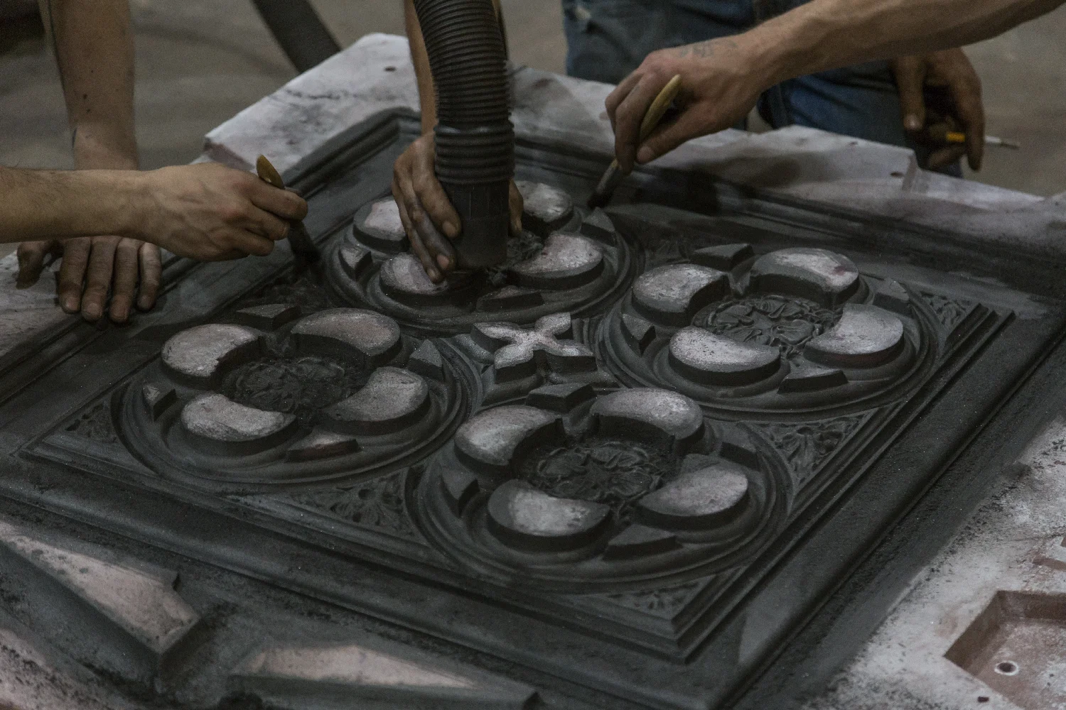 Sand mold being cleaned to remove excess graphite.