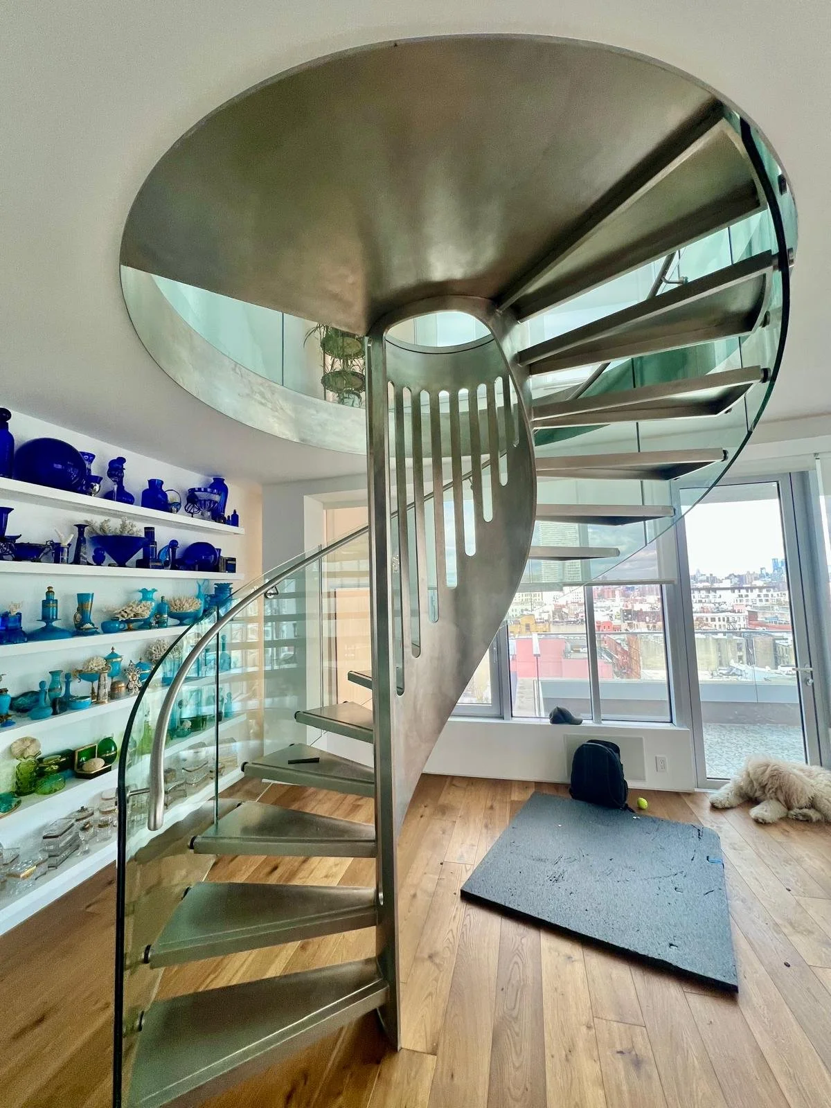 Curved glass railing wrapping a custom metal stair in a New York residence