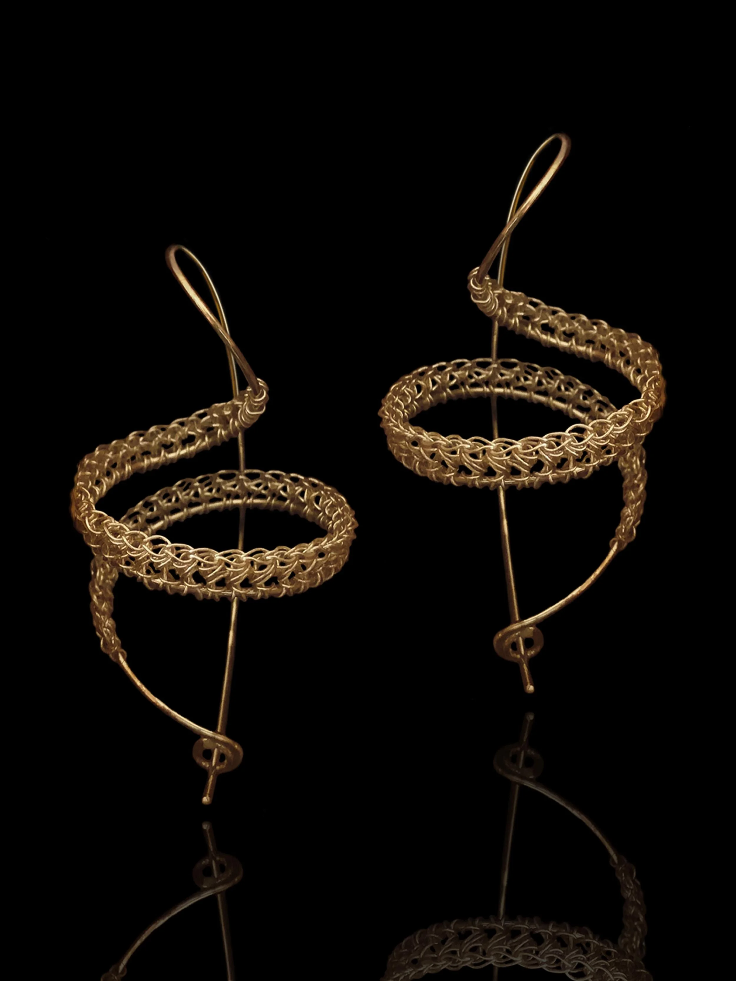 pair of handmade crochet spiral earrings in gold plated silver