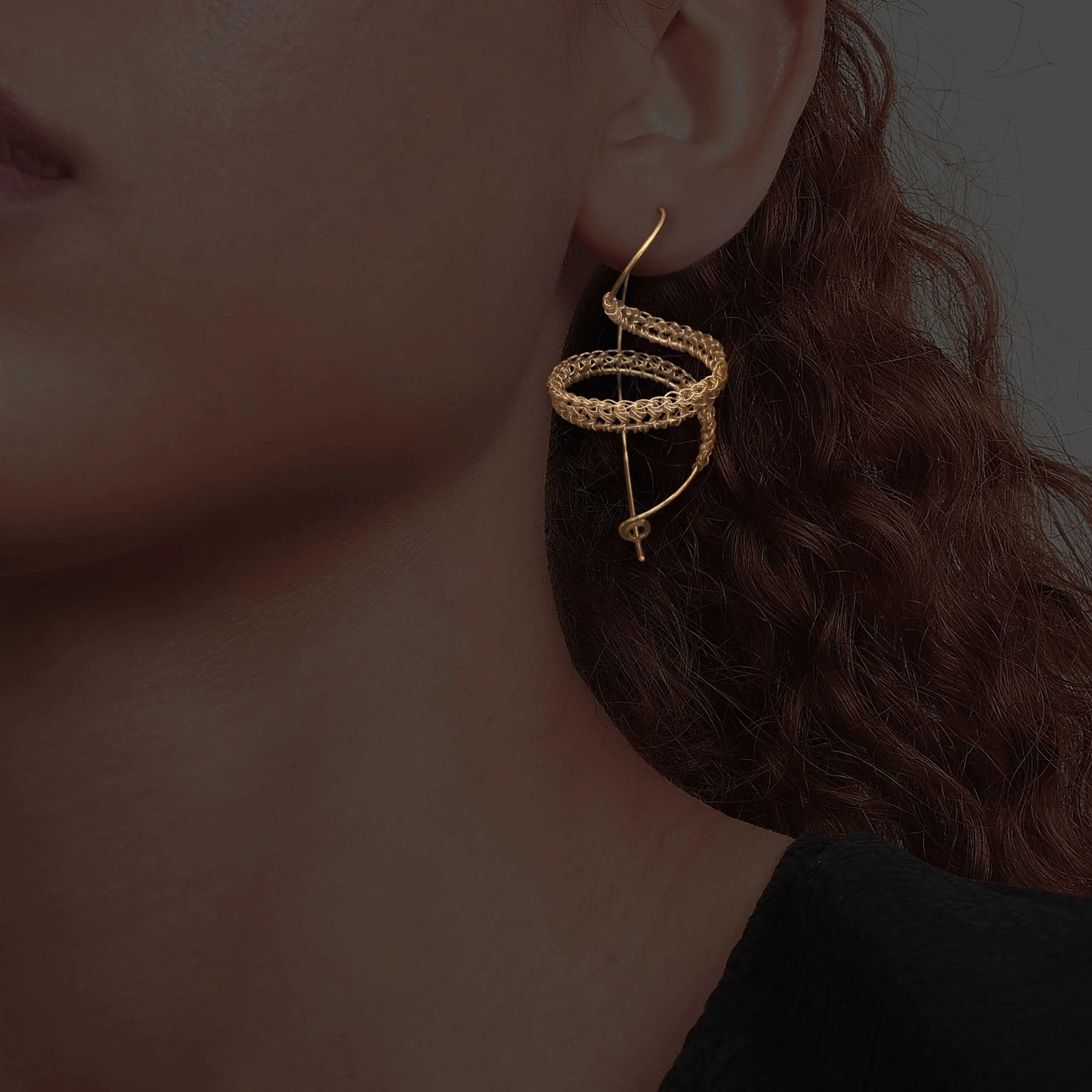 hand crochet spiral earring in gold plated silver in ear