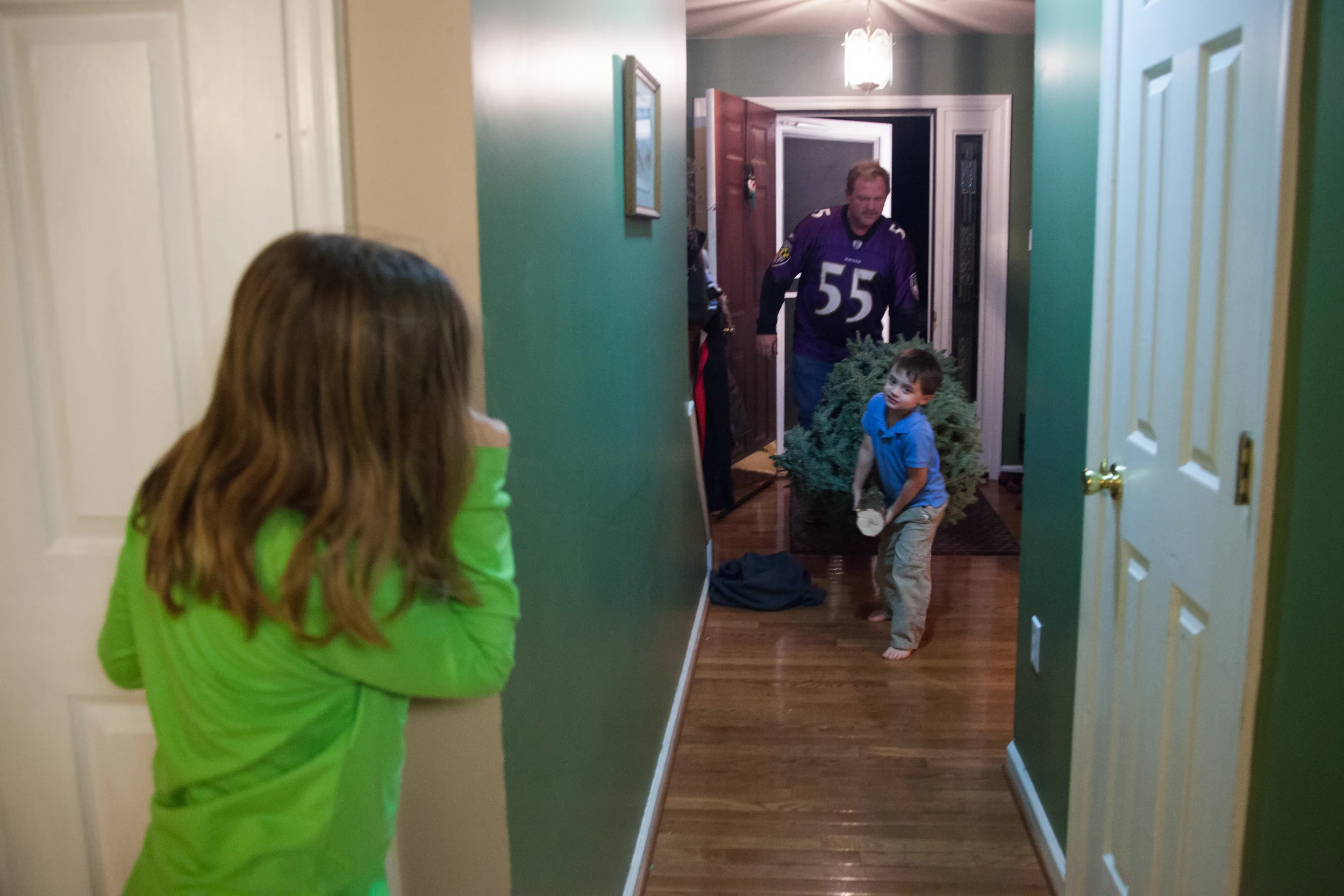  Robin Kelly, 8, watches her brother, Dillon Kelly, 4, and their dad, Shawn Kelly, carry in the Christmas tree at their home in Hagerstown, M.D. on Dec. 6, 2015.&nbsp; 