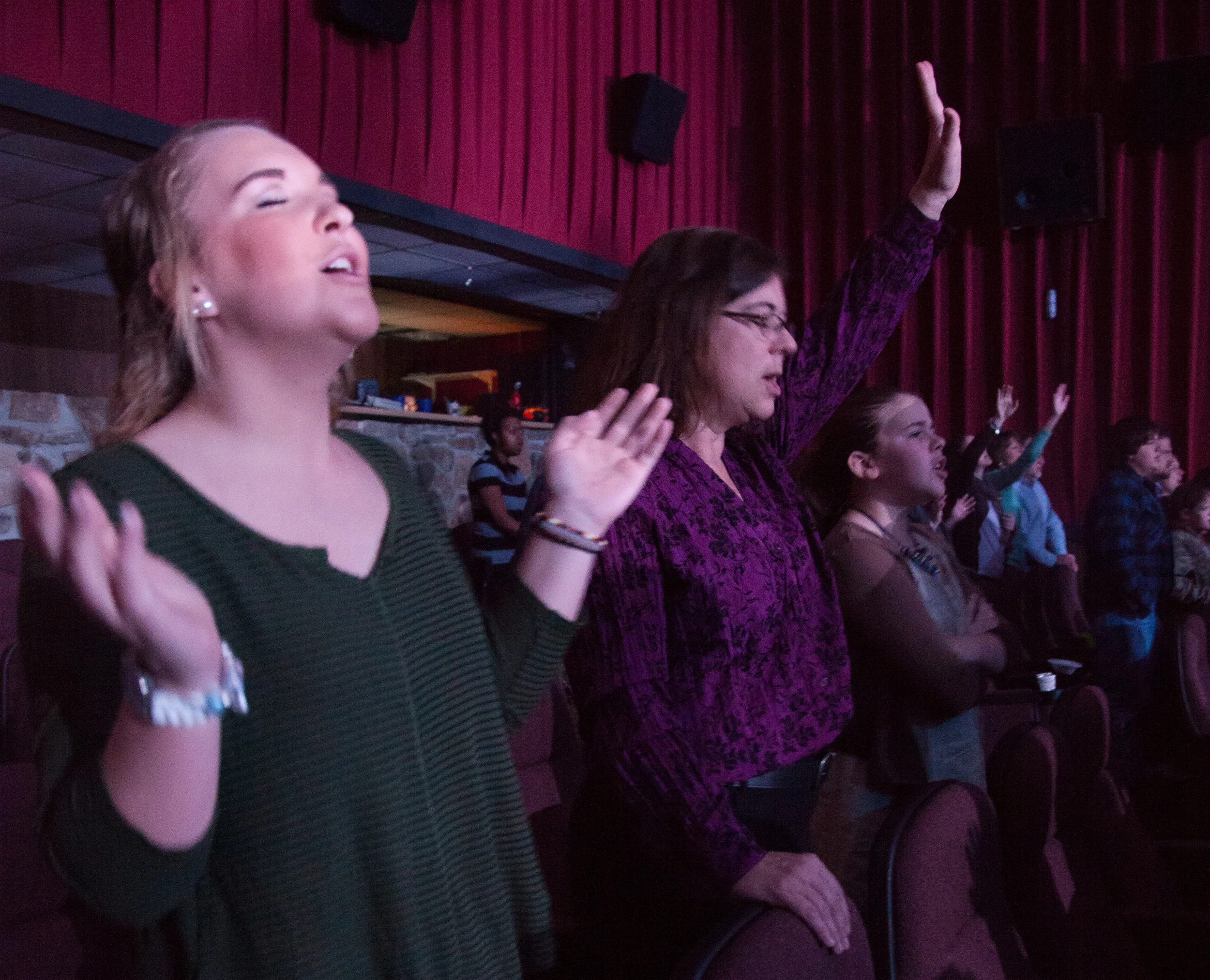  Sydney Kelly, 16, and her mom, Jamie Kelly, raise their hands in praise at Lifehouse Church in Hagerstown, M.D. on Dec. 13, 2015. Lifehouse is inside of an operating movie theater and is geared towards younger Christians.&nbsp; 