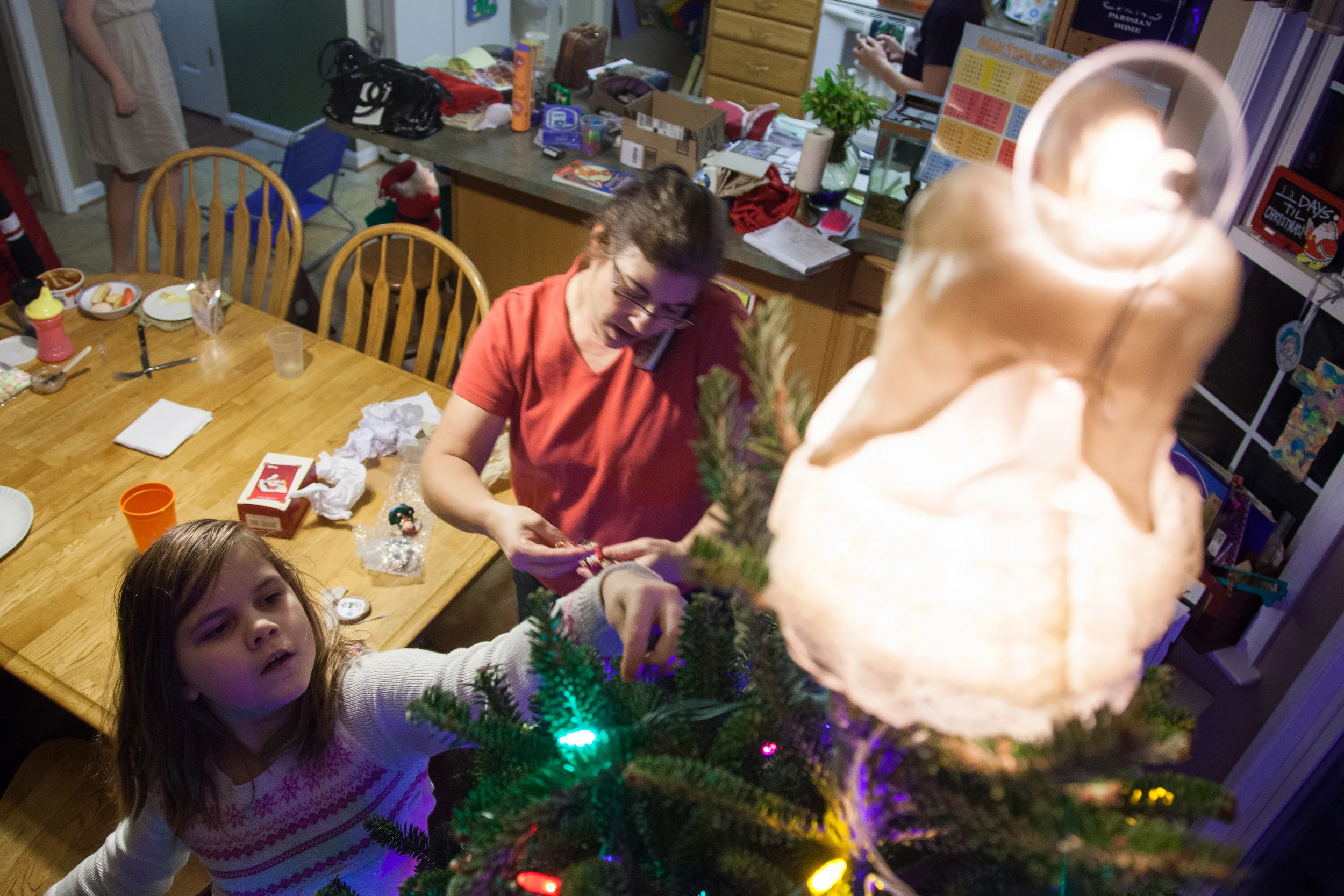  Robin Kelly decorates the Christmas tree while Jamie Kelly calls for take-out at their home in Hagerstown, M.D. on Dec. 13, 2015. “I’m done cooking for so many people,” Jamie says, “I’m getting pizza.” 