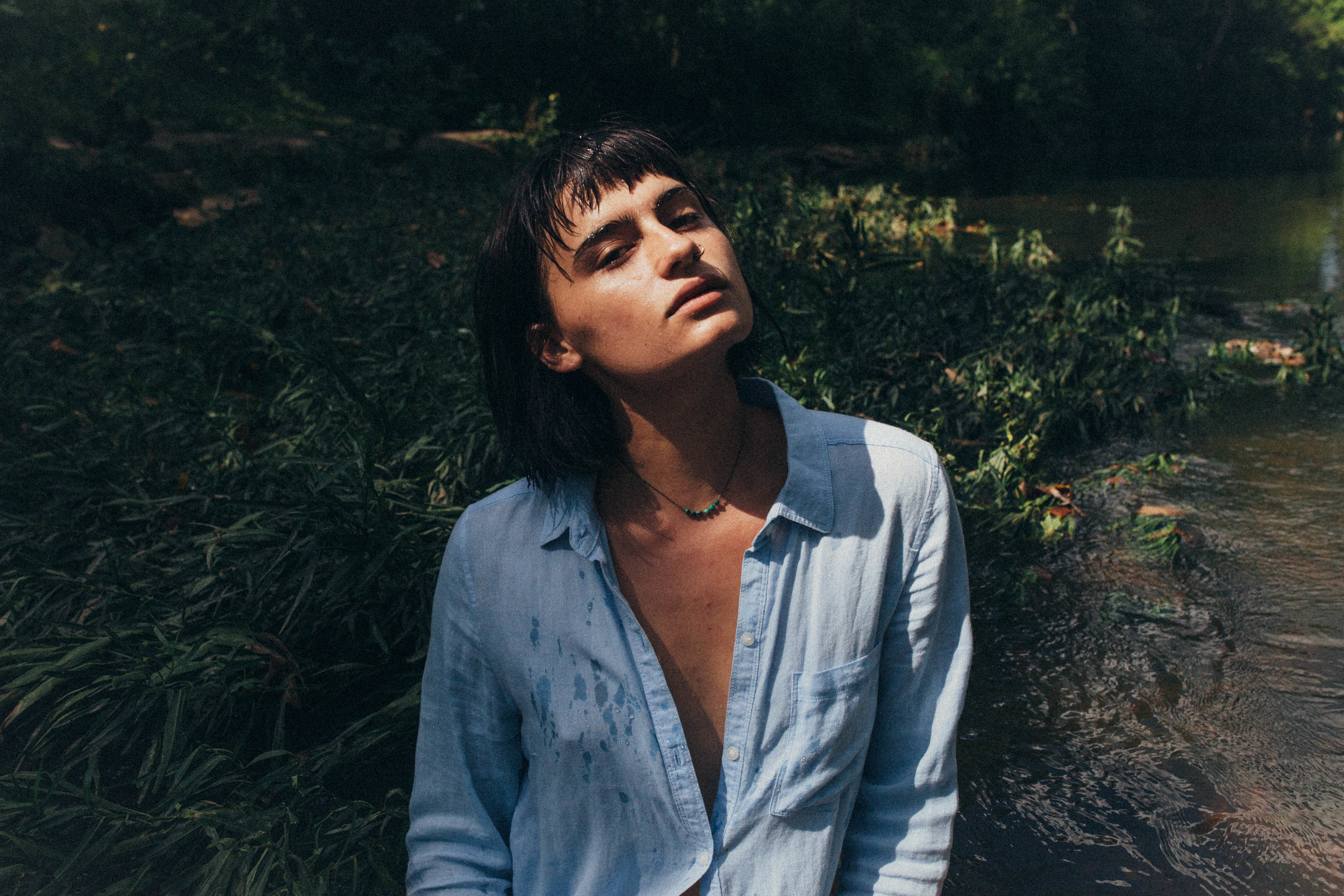 portrait of a dark haired girl in a blue button up in the river in Missouri