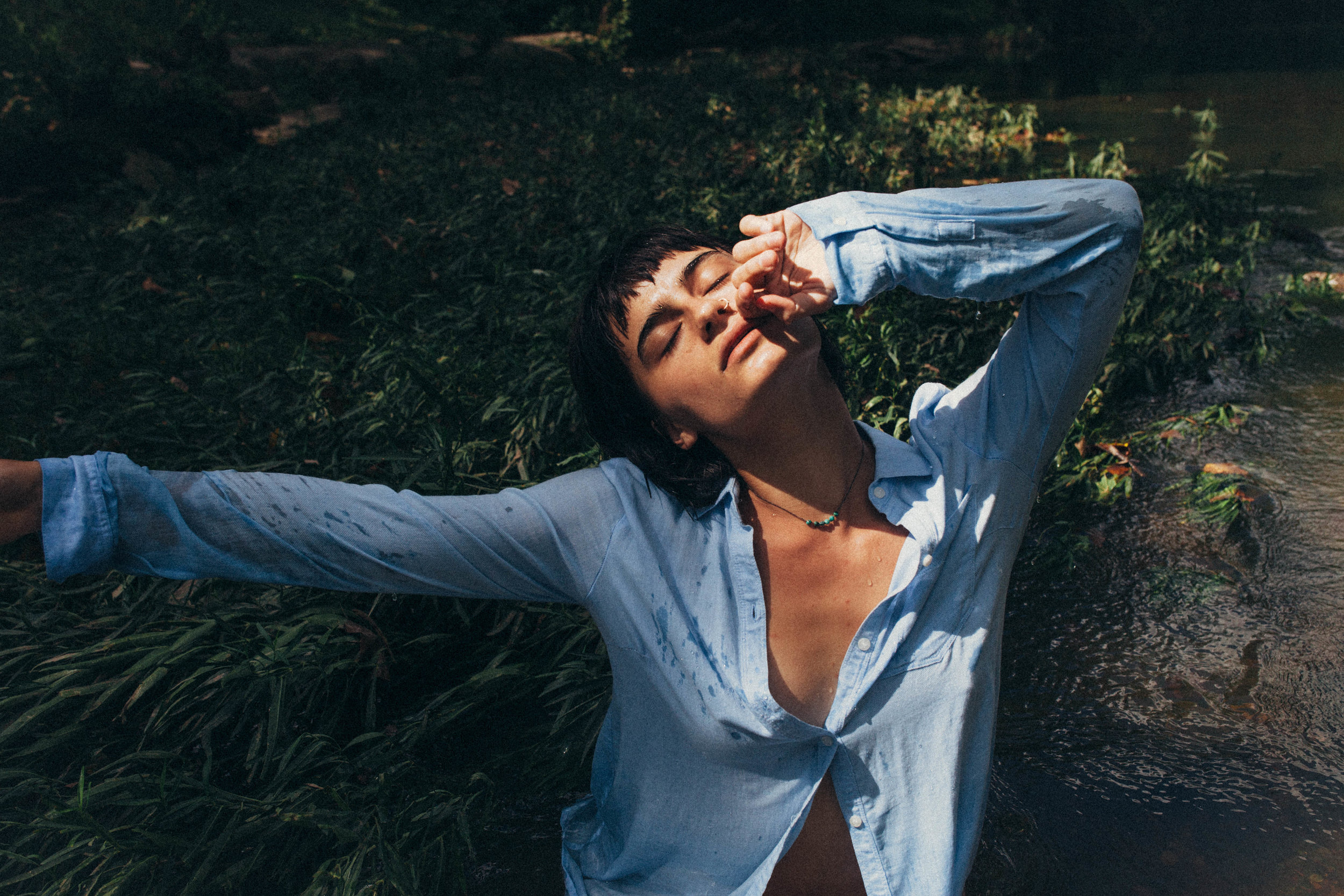 portrait of a dark haired girl in a blue button up in the river in Missouri