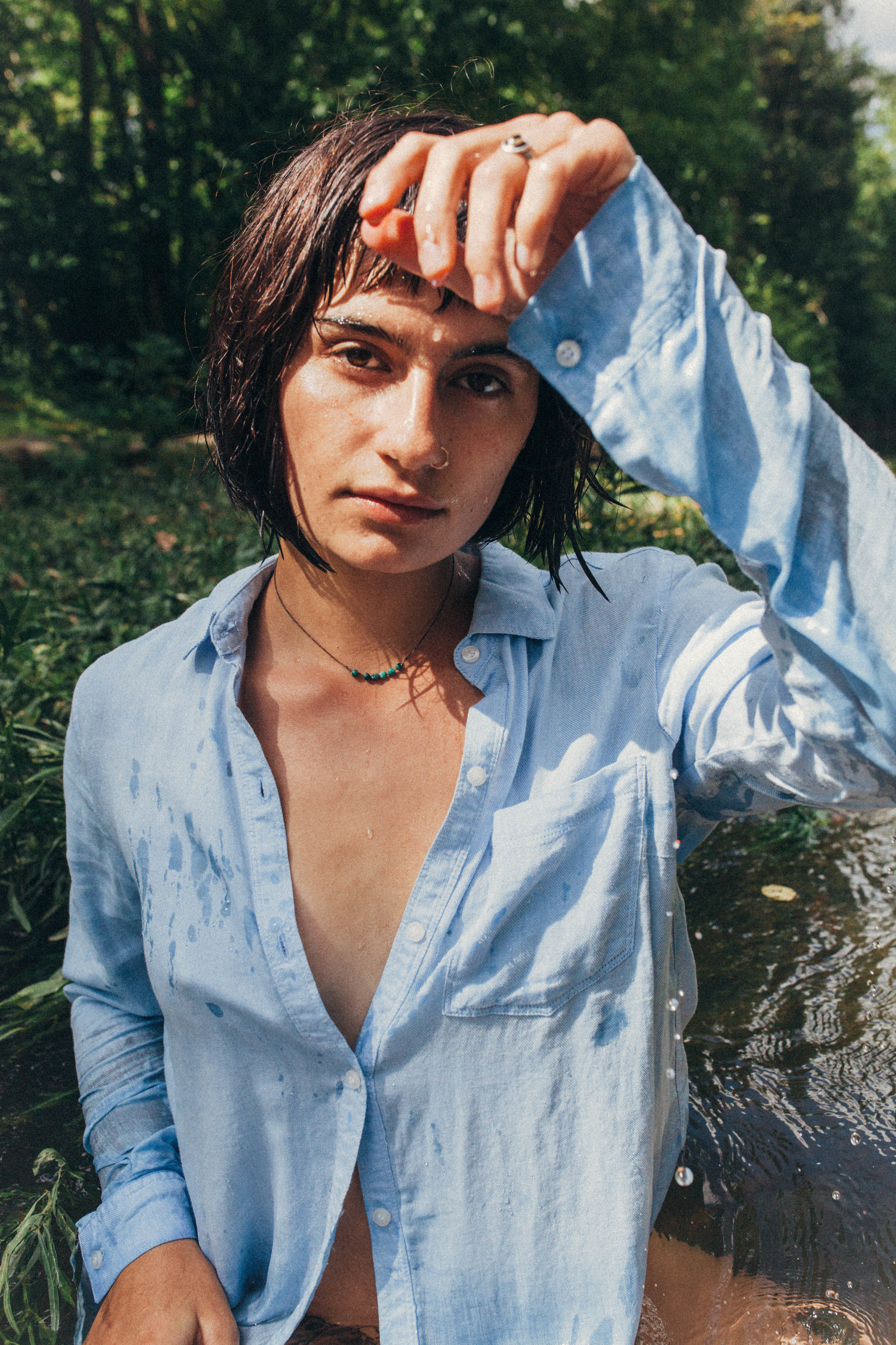 portrait of a dark haired girl in a blue button up in the river in Missouri