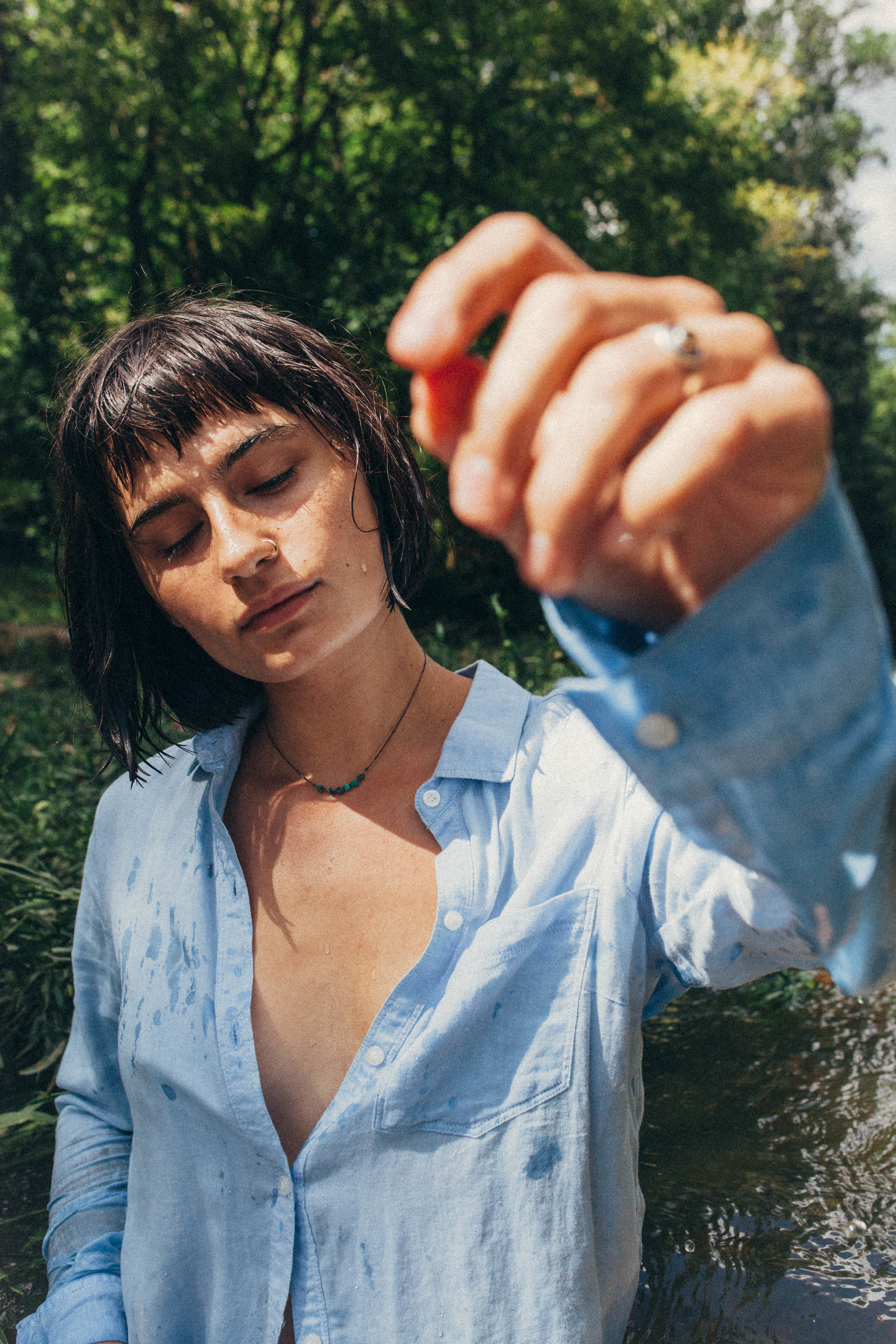 portrait of a dark haired girl in a blue button up in the river in Missouri