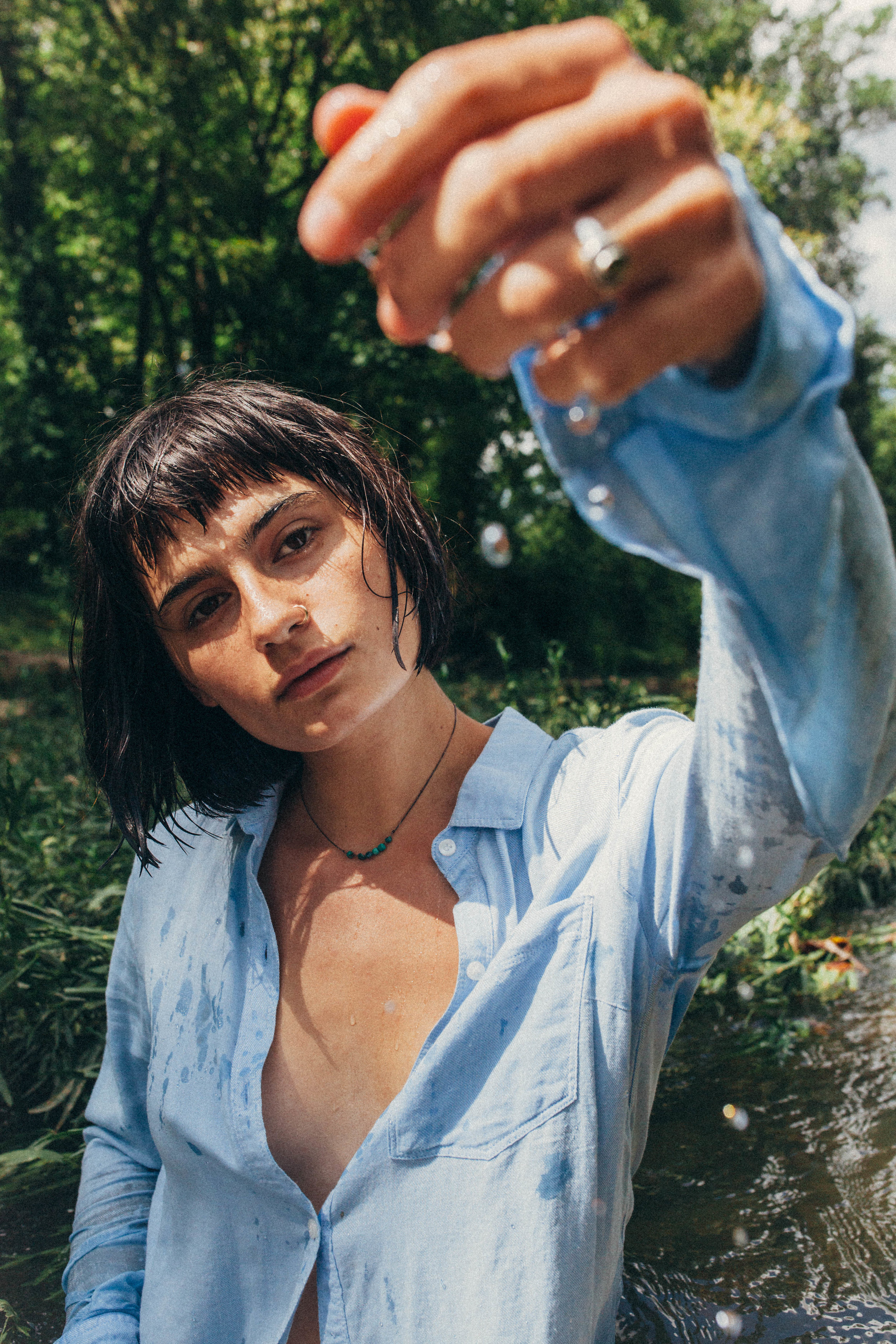 portrait of a dark haired girl in a blue button up in the river in Missouri