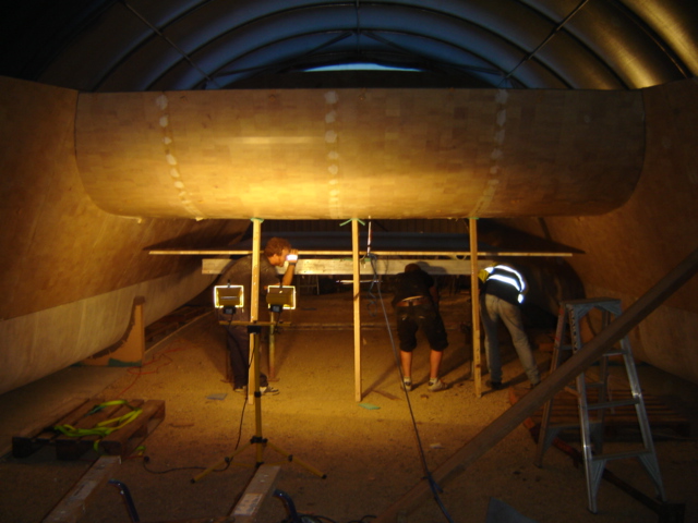 Raising the bridgedeck panel into place for bonding and glassing with Acro Props. We completed the main assembly in 10 days. It was one of the most rewarding times of the build as the boat goes from a pile of parts to a defined structure you can move within. May 2010.