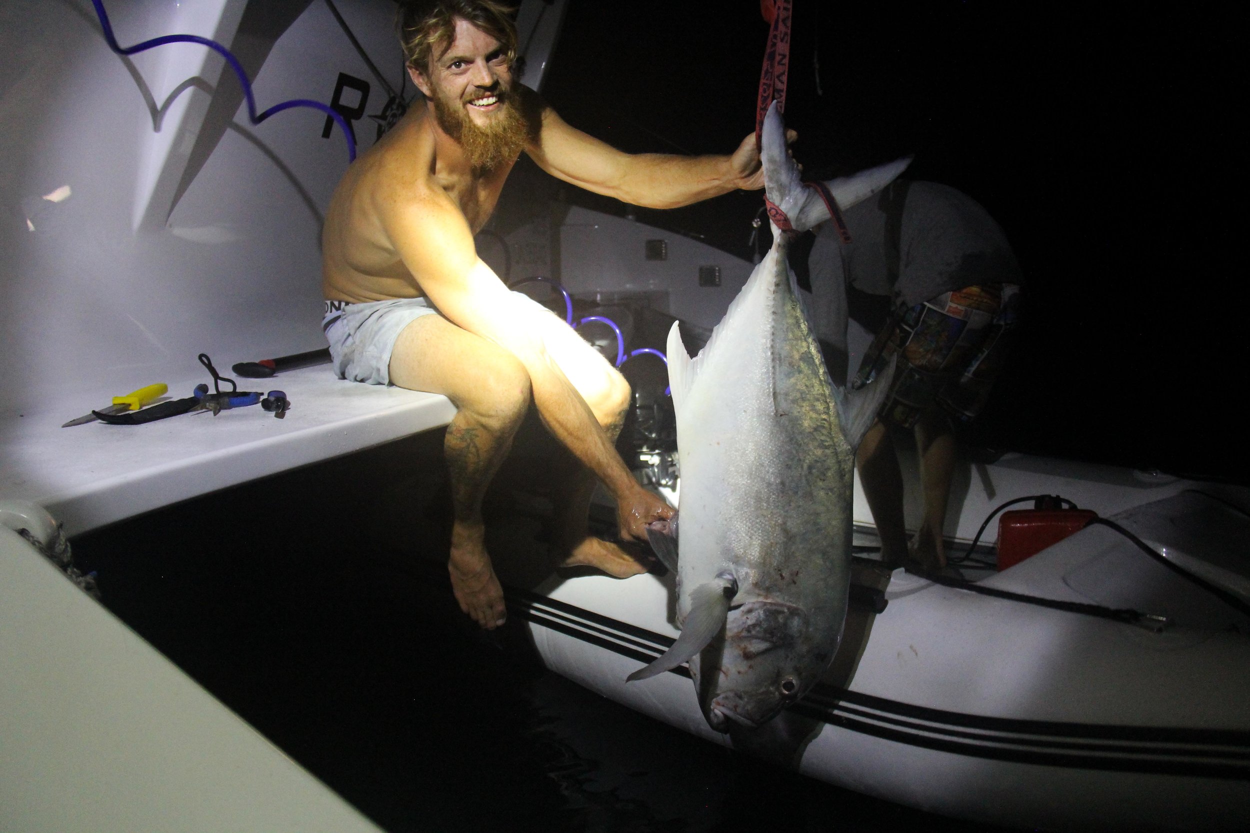 Andrew with the Giant Trevally Michael and himself caught off the back of roam on anchor in the lagoon. We gave the monster of a fish to the Village.