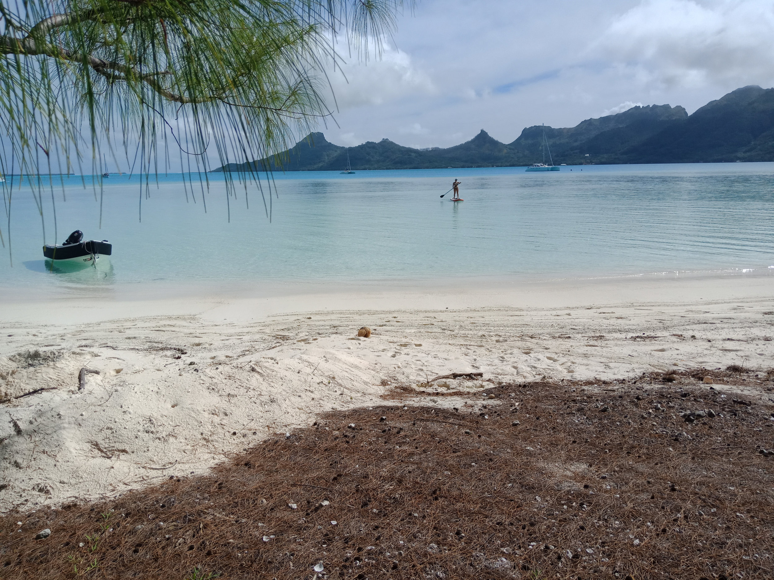  A calm clear day at Motu Piscine. Kopiko (our Oc Tender) anchored in the shallows and Roam Crew out for a paddle on the inflatable  