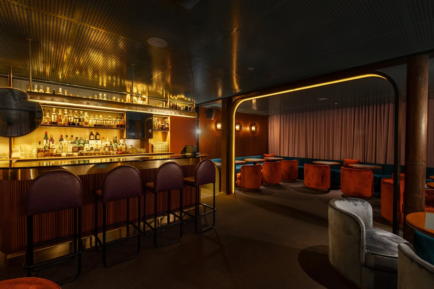 Warm gold-and-red interior at Jigger & Pony in Amara Singapore
