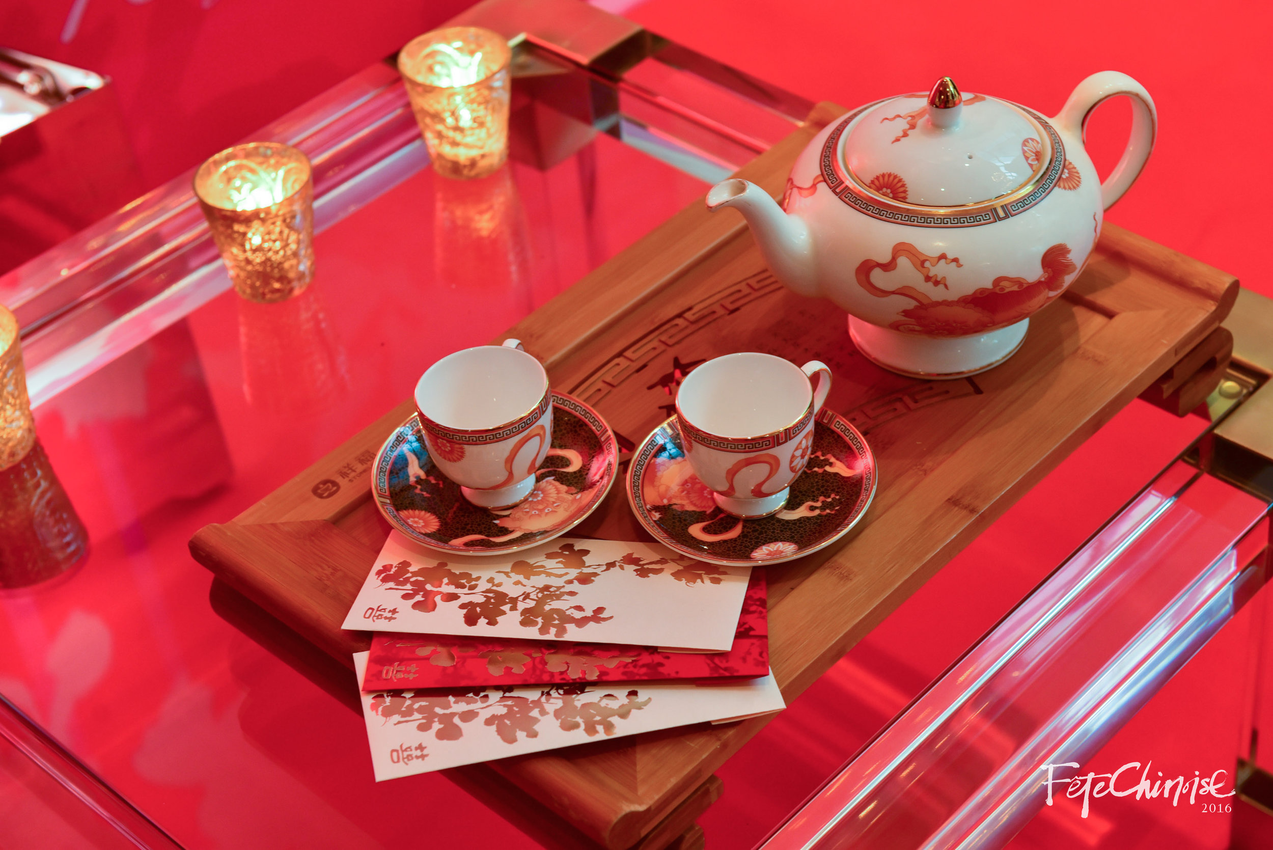 A modern take on the traditional tea ceremony, this vignette features the custom china at Shangri-La Hotel on a wooden tea tray, with beautiful lucky money pockets by PALETTERA.