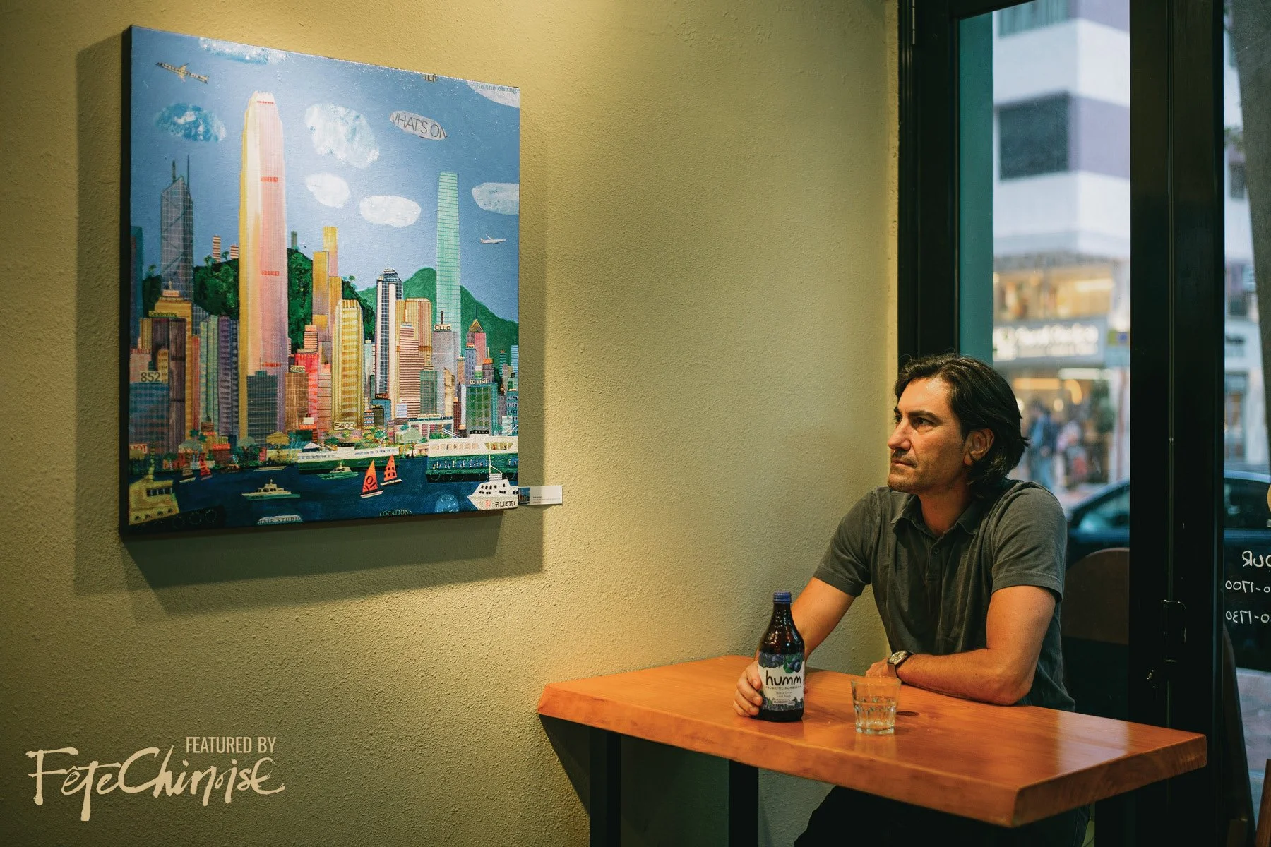 Francesco Lietti looking at his painting in a cafe. PHOTOGRAPHY: Thien-Ty LY