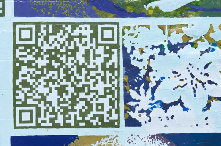  The design contains 22 scannable codes that anyone with a smart phone can scan, to have an enhanced experience of the mural. A passer by can scan a code within the mural and be taken to a number of audio clips from our workshops with the Prison Soci