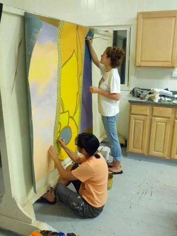 Janet Sato, the most respected art teacher on the island pops in with another student to lend a hand on the last day of painting in the studio. 