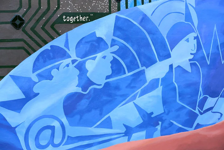 The blue fabric pattern, weaves another narrative about the interconnectivity of work throughout the economies. People in numerous professions are dependent on the work of their neighbor. These connections are symbolized by the "bursts" throughout the blue cloth. 