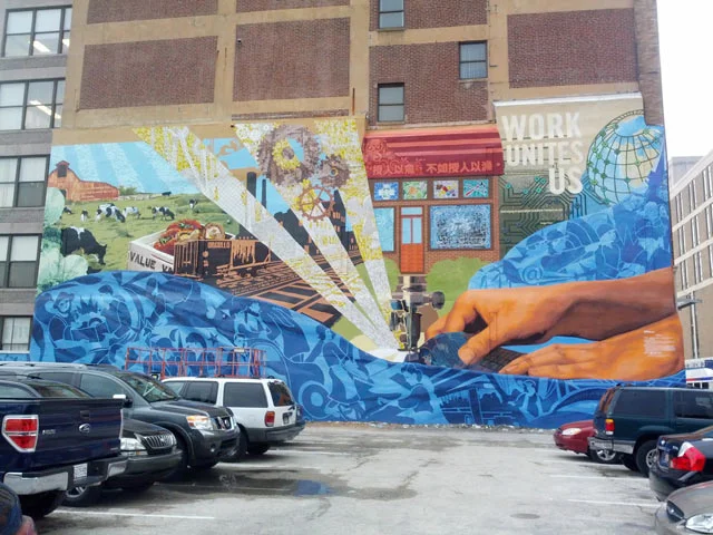 While there is a central image of one “worker” on the mural, the images of work through different economies and as shared between the interconnected fabric of society shows how much we must rely on each other to be successful at work and in our live