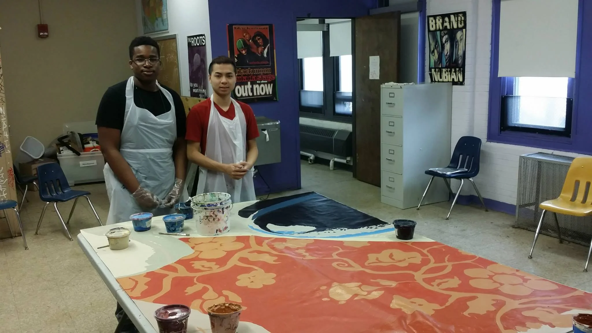 Two of the SEAMAAC students helping with the final workshop in their School before the mural's installation. 