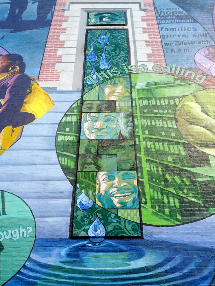 The glass portraits fall within 3 3'x20' "windows" set inside of faux stonework taken from the architecture of the historic 100+ year old fire house the mural is attached to.