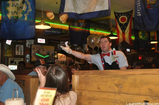 Lamberts employee tosses a pair of warm rolls to a waiting customer.