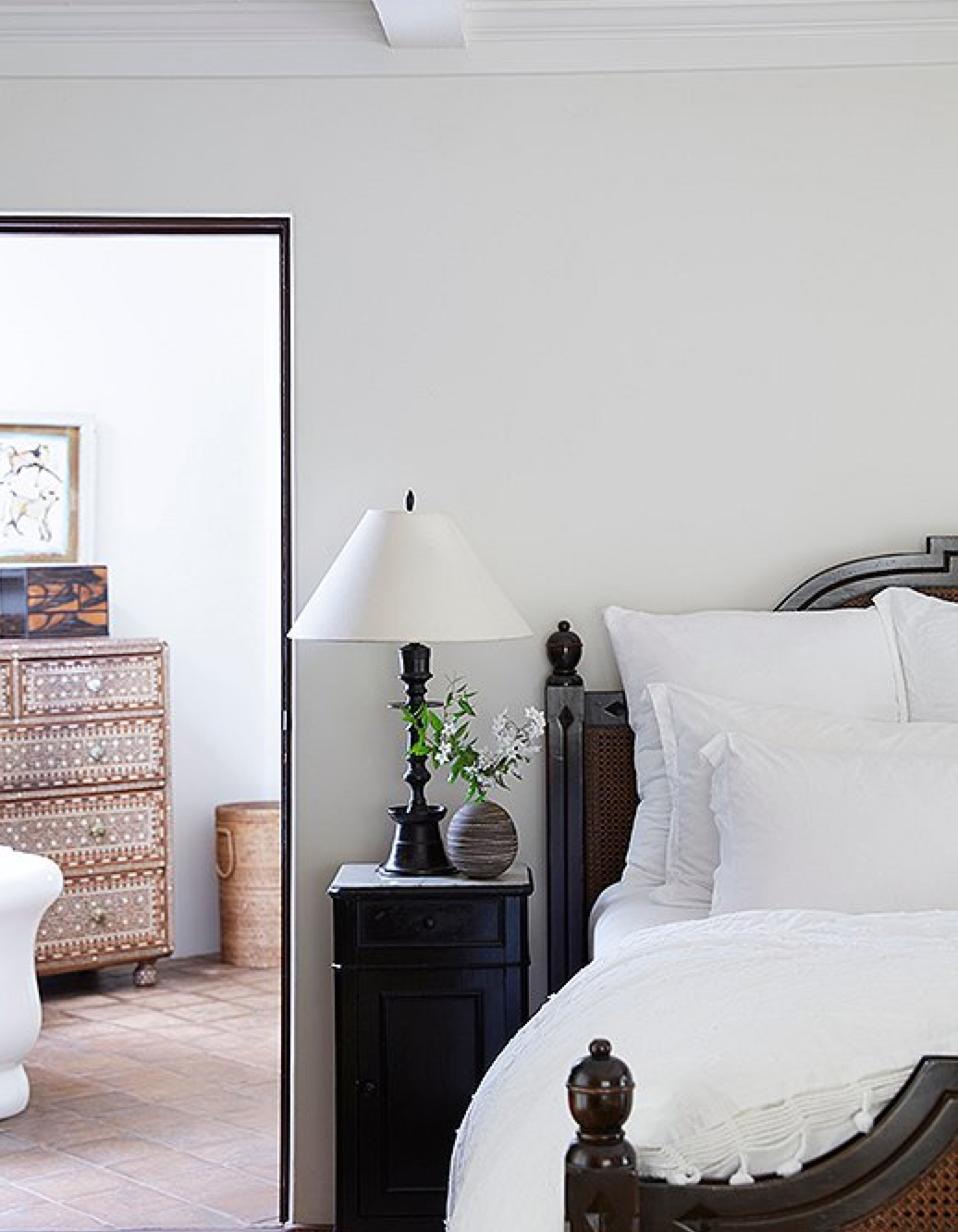 The master suite is a serene, breezy retreat. The centerpiece is a striking wood-and-wicker bed and set of nightstands “They’re custom by Brenda Antin and a future heirloom for our daughters,” Kendall says. Nightstand essentials? “Books, lip balm, and hand cream.” The bedding is Matteo.
