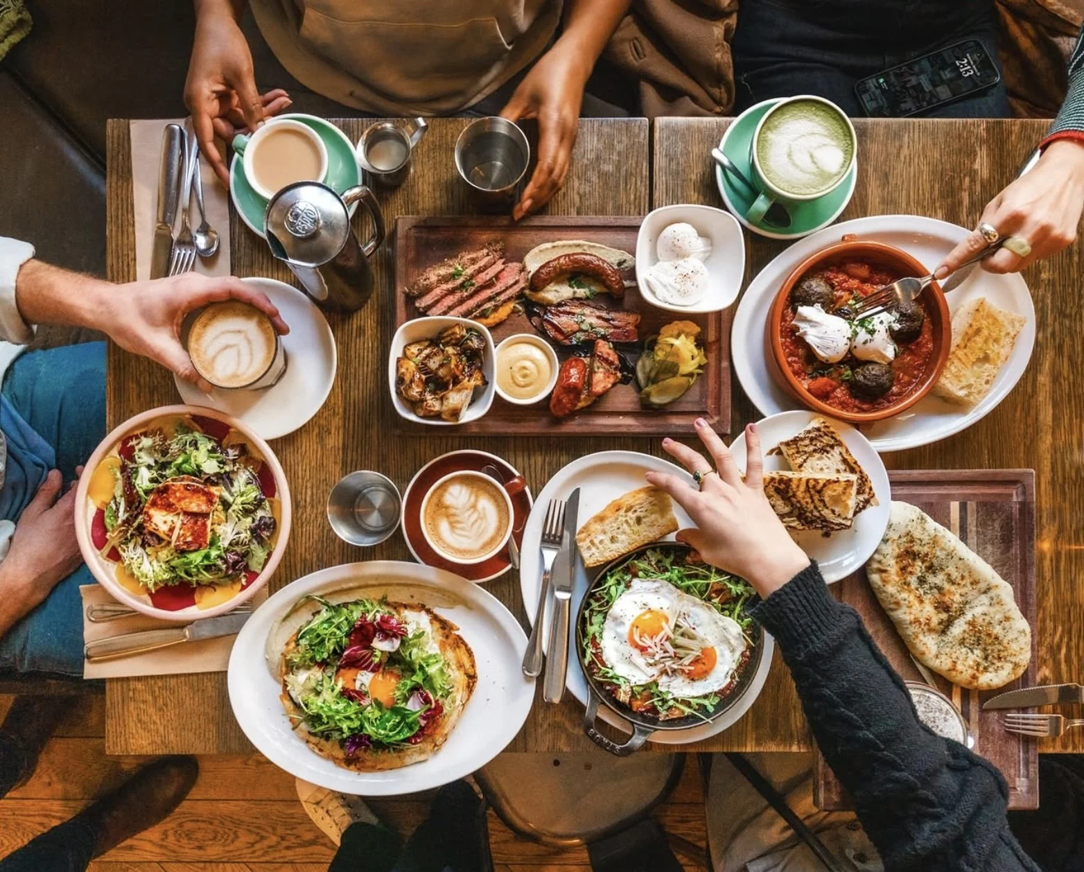 Brunch dishes served with coffee and craft cocktails at a café table