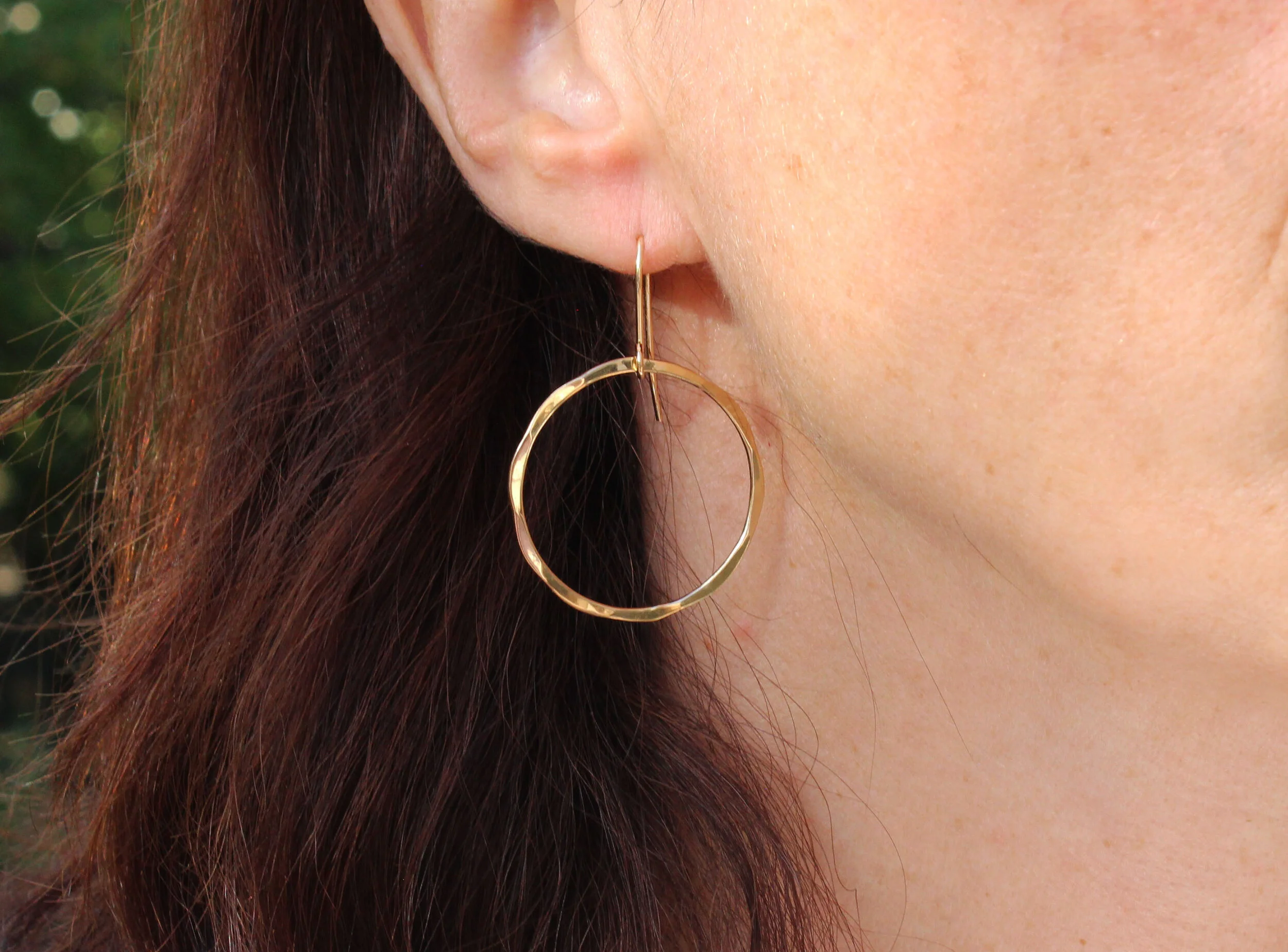 large gold hoop earrings being worn