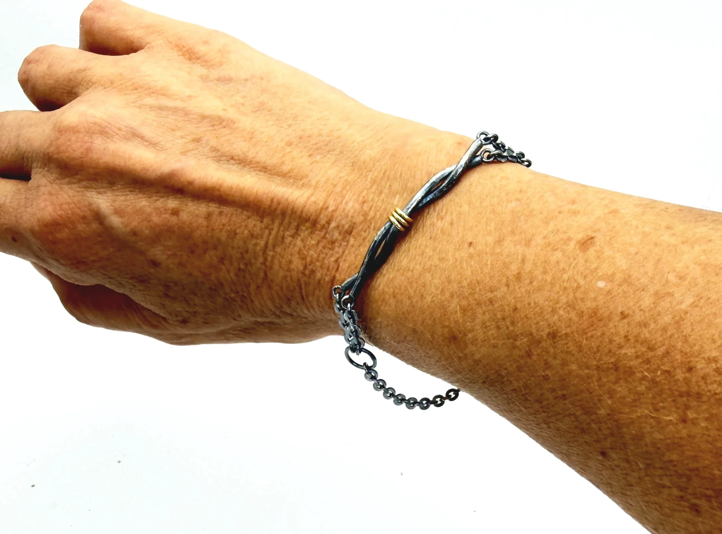 Oxidized silver twist bracelet worn on a wrist