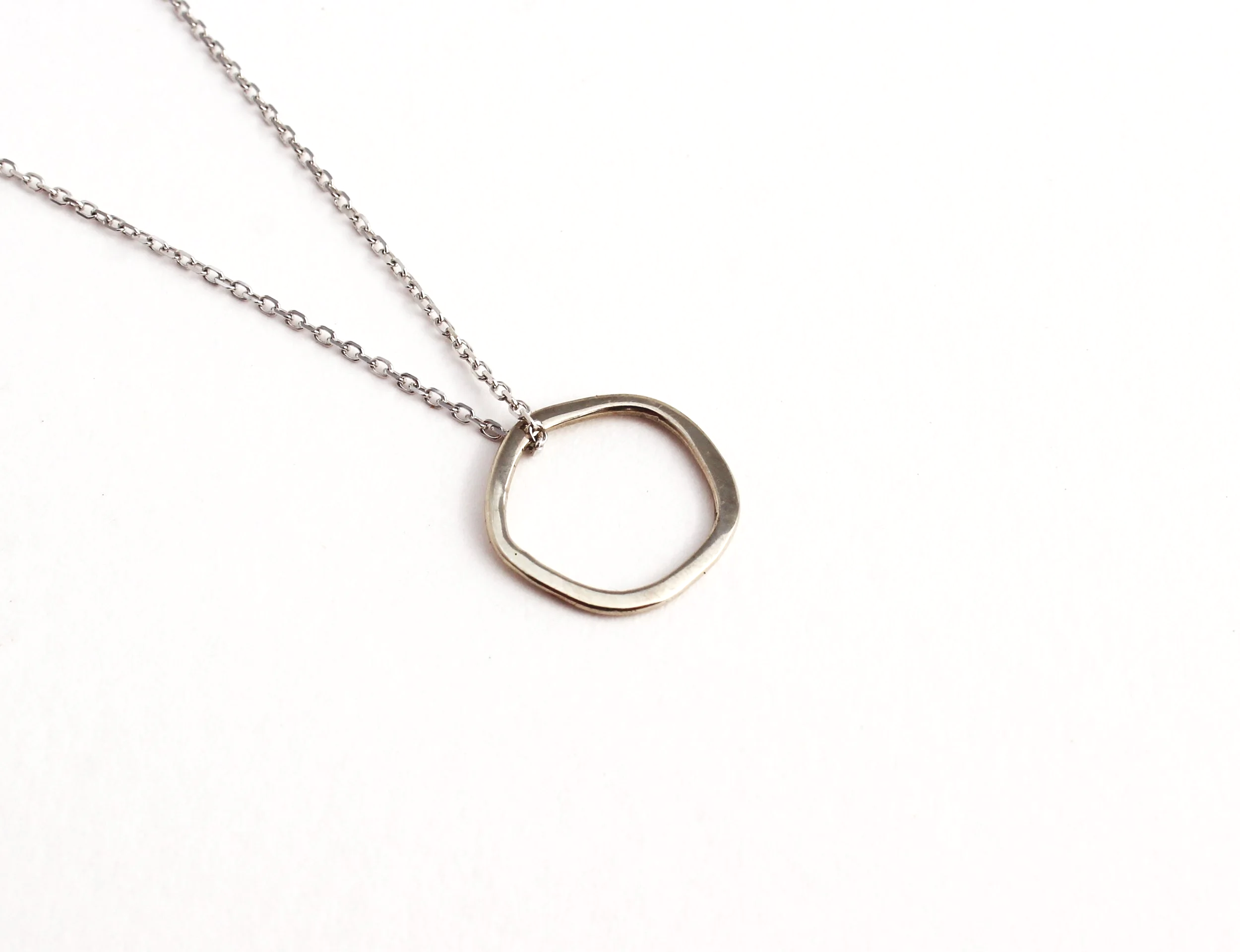 irregular shaped small circle pendant in white gold