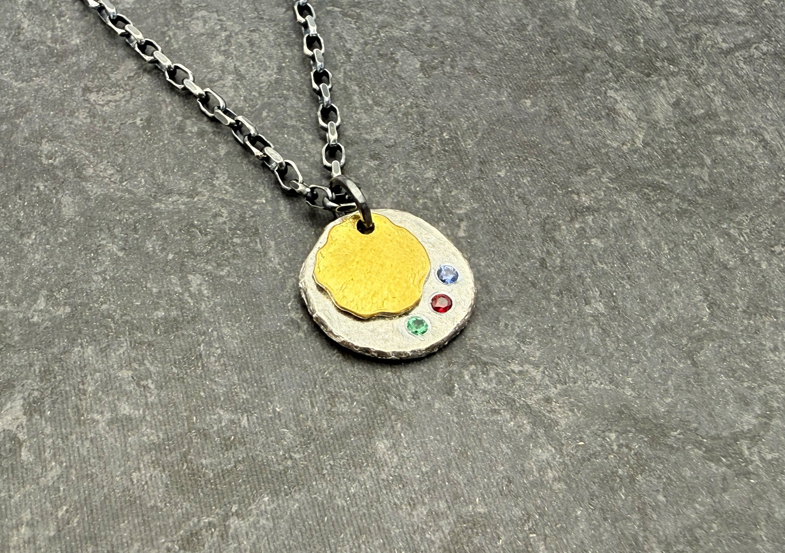 Keum boo gold and oxidized silver disc pendant on dark slate