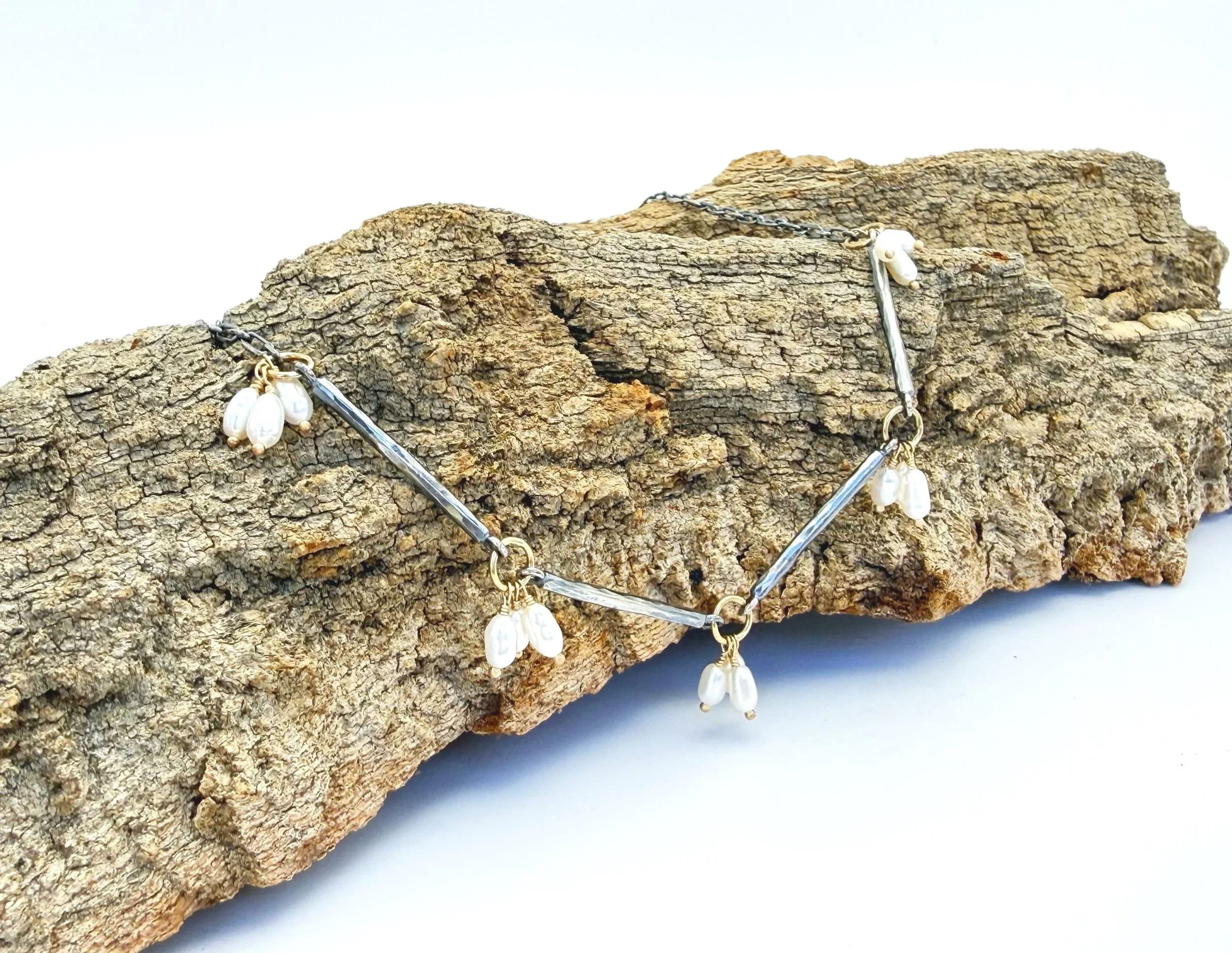 Pearl and oxidized silver bar necklace on weathered wood